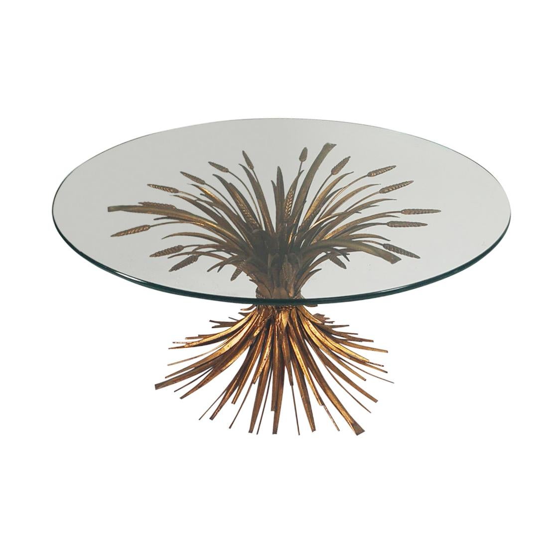 A vintage sheaf of wheat coffee table from Italy circa 1960's. It features gold gilded metal base with thick clear glass round top.
