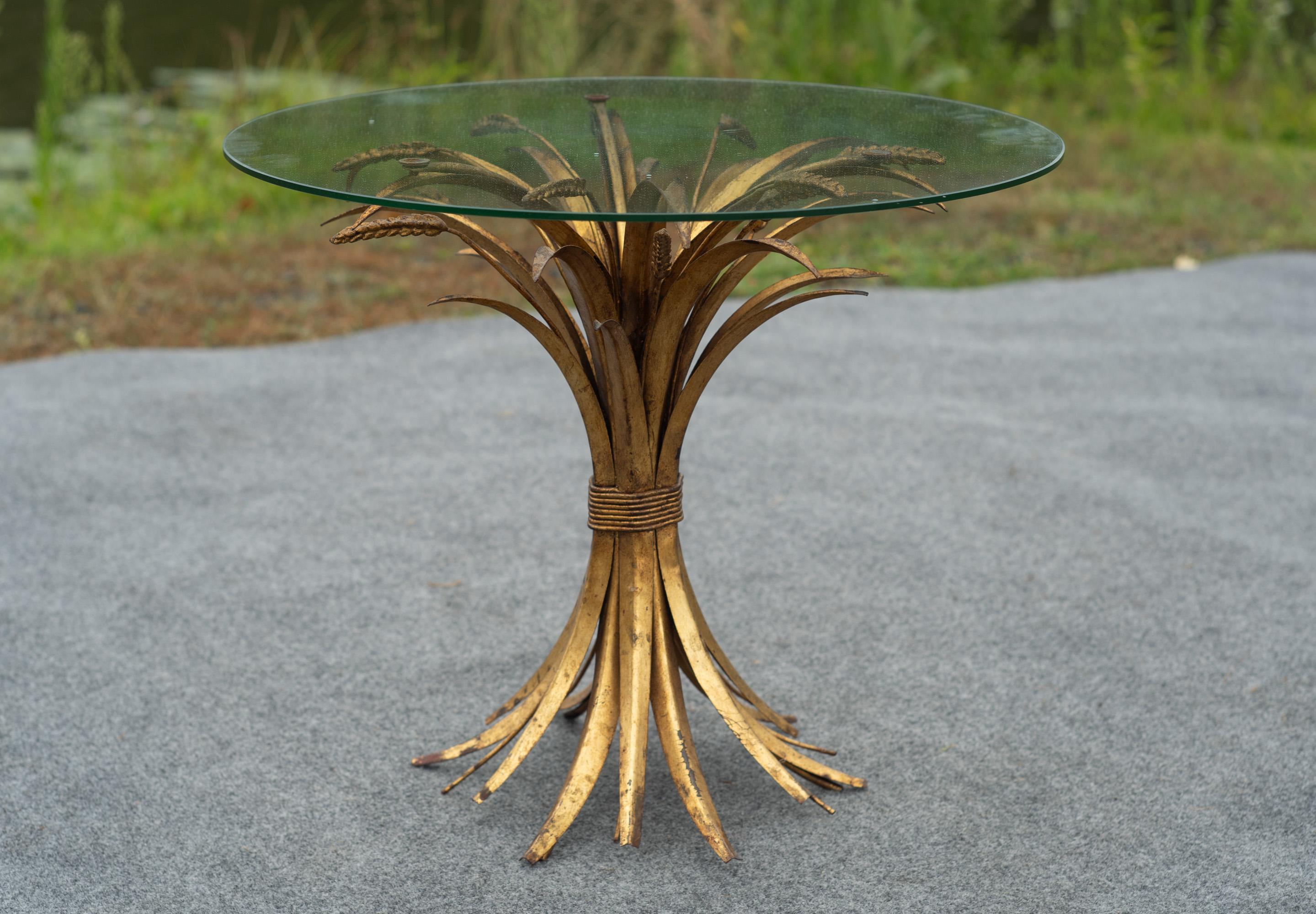 Tavolino vintage in covoni di grano proveniente dall'Italia e risalente agli anni '60 circa, con base in metallo dorato e piano rotondo in vetro trasparente. Questo tavolo ha charme, qualità costruttiva italiana e dimensioni perfette per qualsiasi