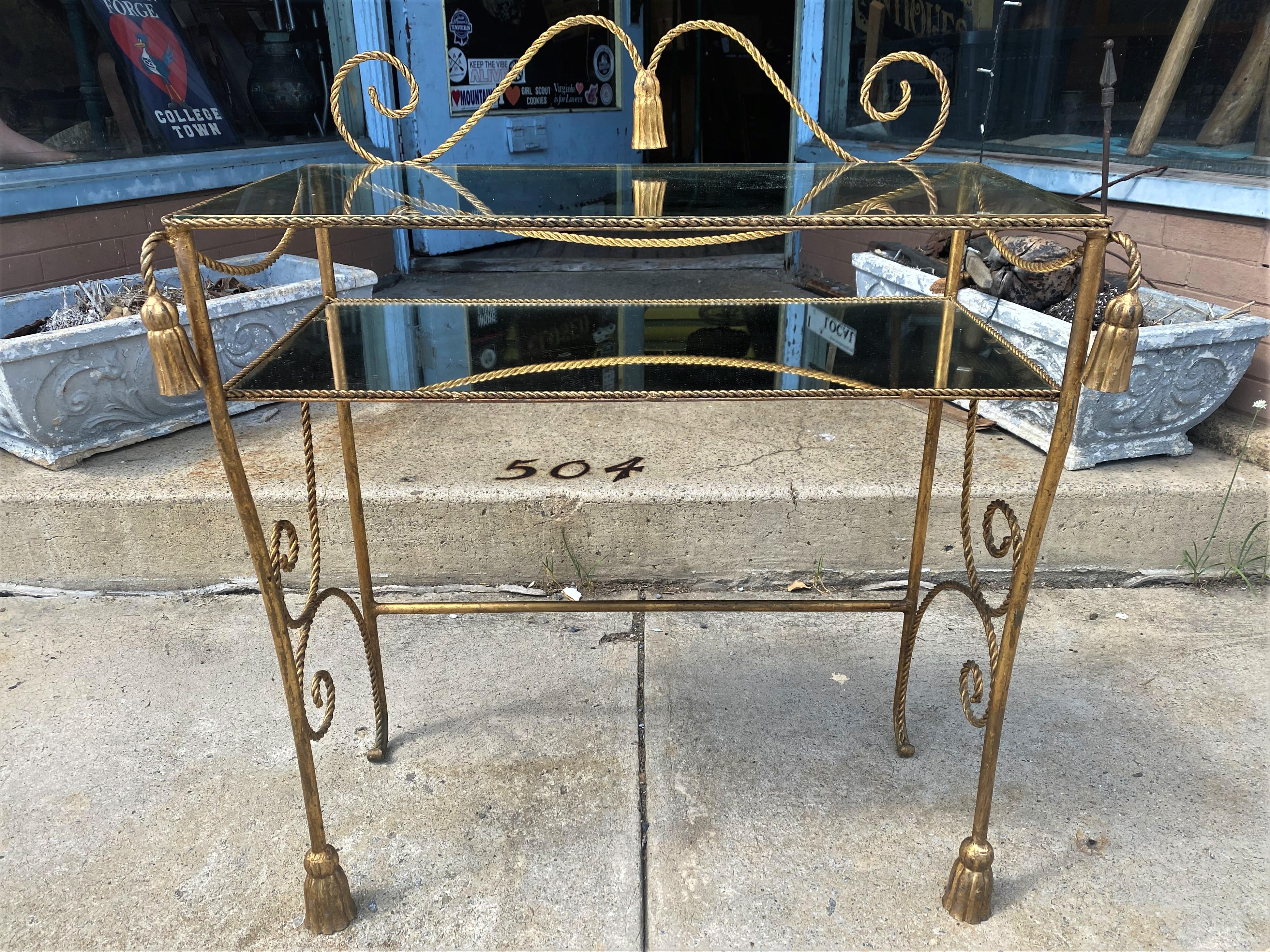 This is a very sweet Hollywood regency Italian gold finished metal vanity with glass top and a mirrored shelf (There are chips in the mirror on either end which I have photographed and will not be noticed at al when this is full of your perfume