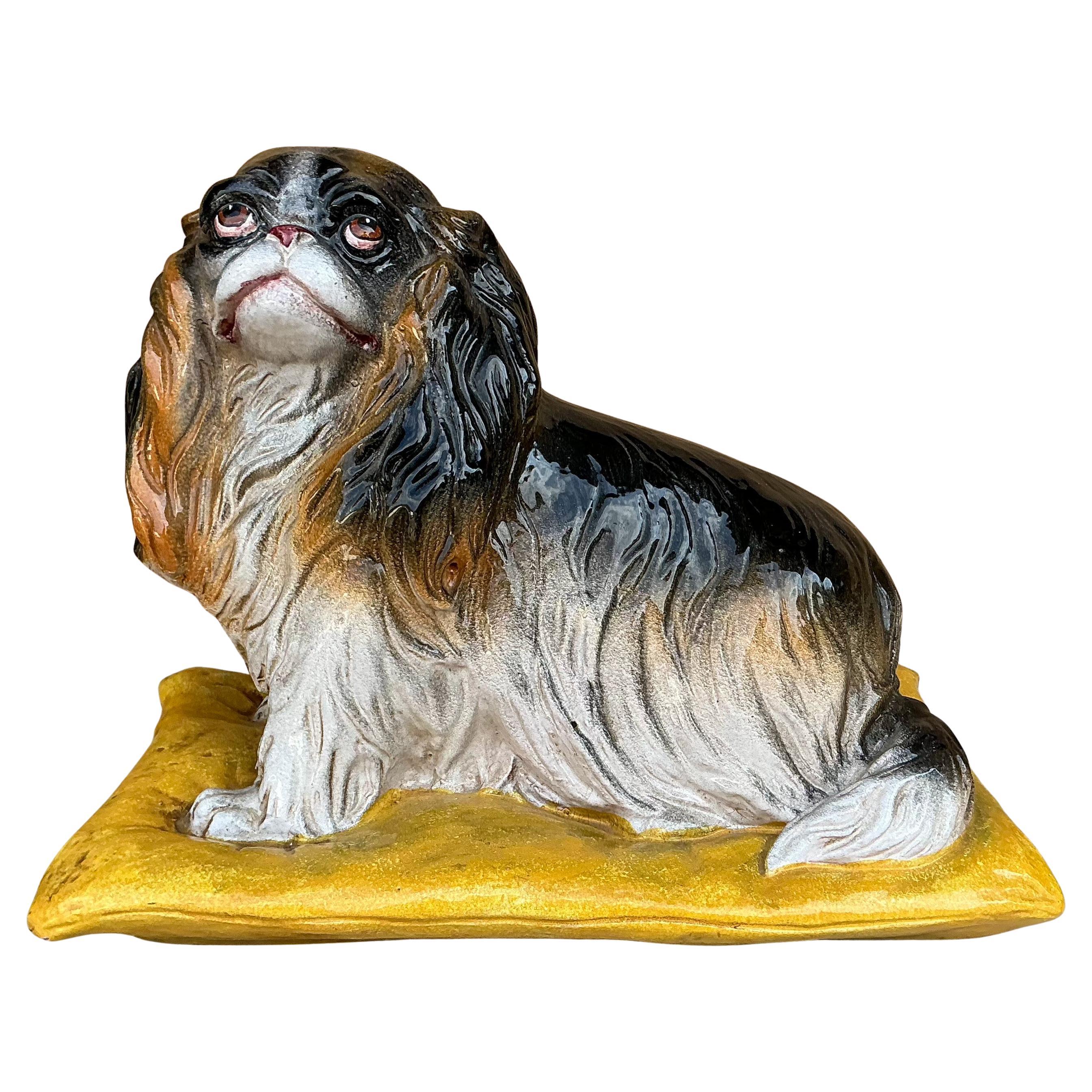 This is a Hollywood Regency Era Italian terracotta spaniel dog sitting on a yellow pillow. He is a mid-century find and in very good condition. He is marked.