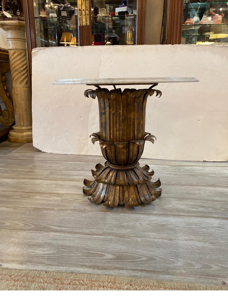 Chic Italian marble and gilt metal round side table. Hollywood regency glam with a white marble top with engraved and dyed pattern. The urn form base of gilt metal leaves shaped to form an elegant table. The marble with no breaks or chips, light