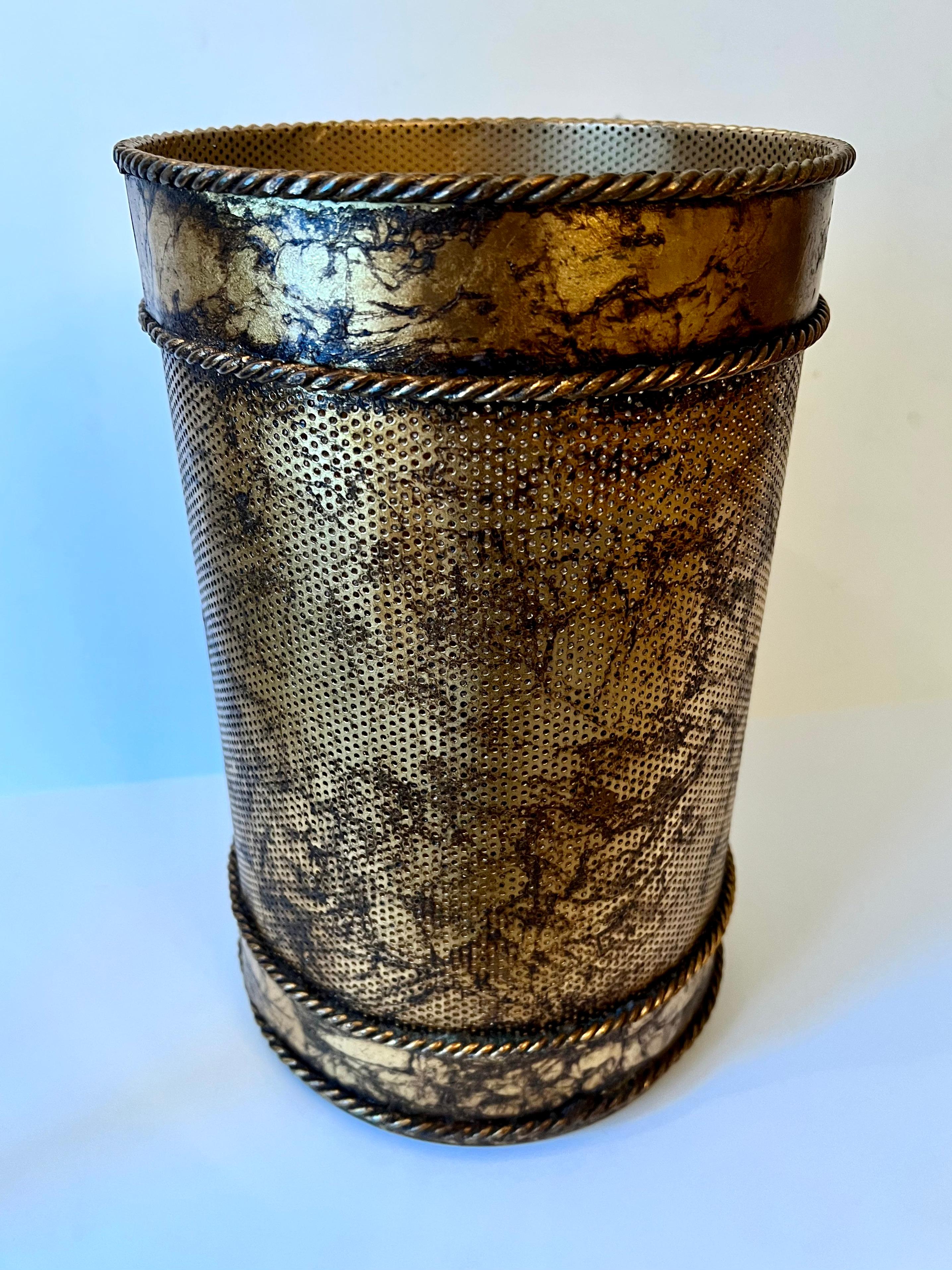 A gold metal waste bin or can.  The piece is very mid century, Hollywood regency.  a wonderful addition to the guest room, bathroom or office.  The gold is variegated and has two braided details.