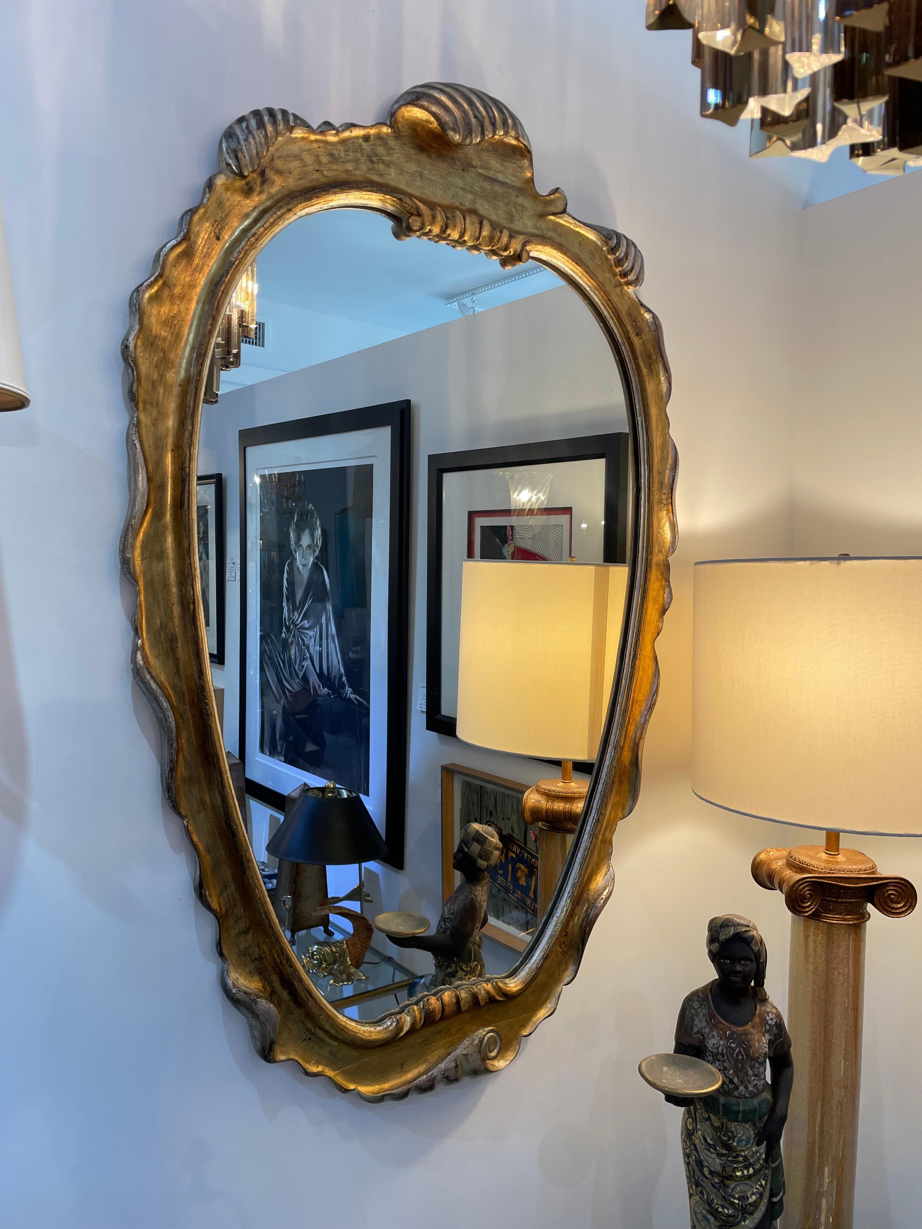 Questo specchio Hollywood Regency, elegante e chic, ricorda molto i pezzi creati da Dorothy Thorpe.  Il pezzo è una combinazione di foglie d'oro e d'argento. 

 