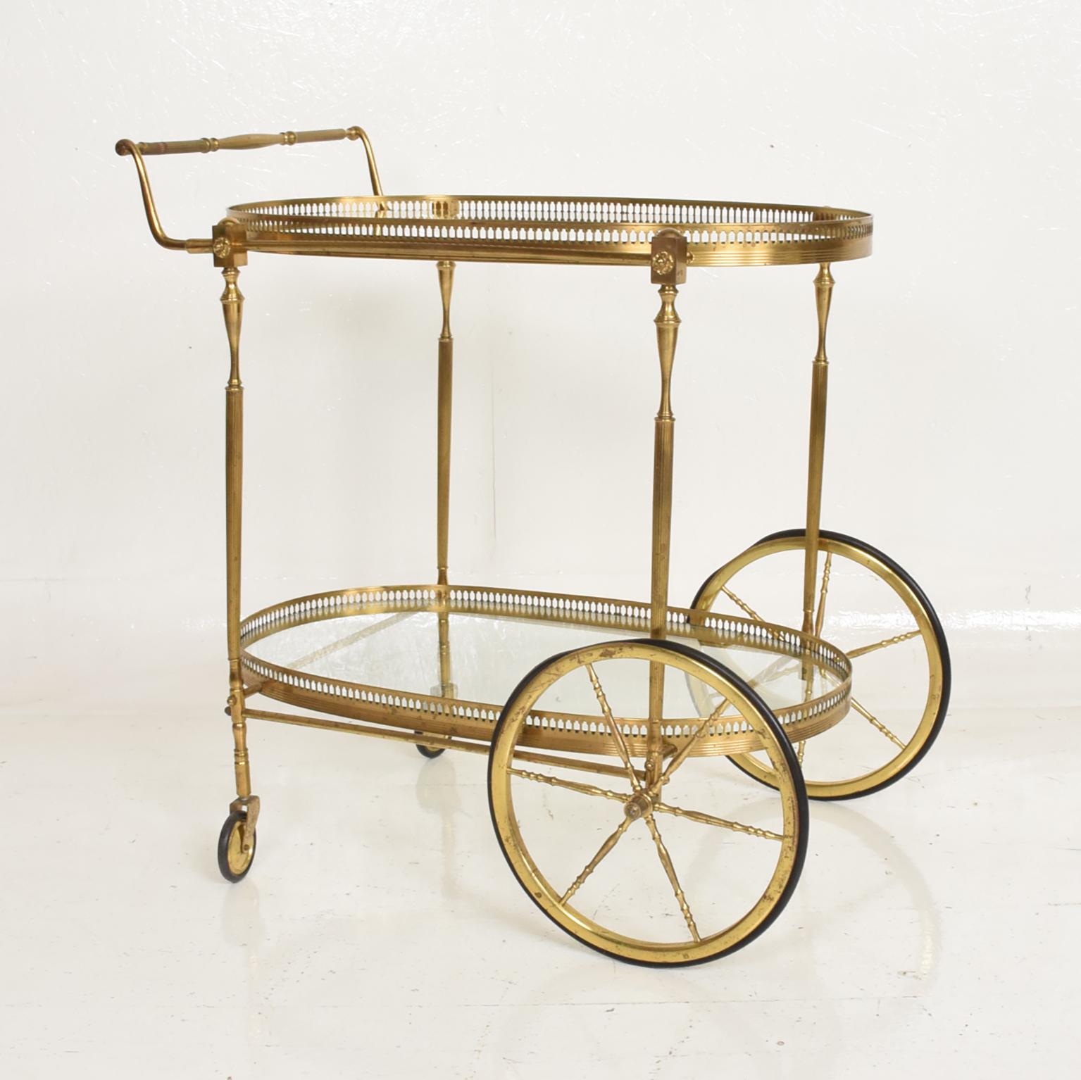 For your consideration, an Italian service cart. Two tiers. Made in brass with rubber wheels. 

Two glass shelves in an oval shape. 

Italy, circa 1960s.

Dimensions: 31