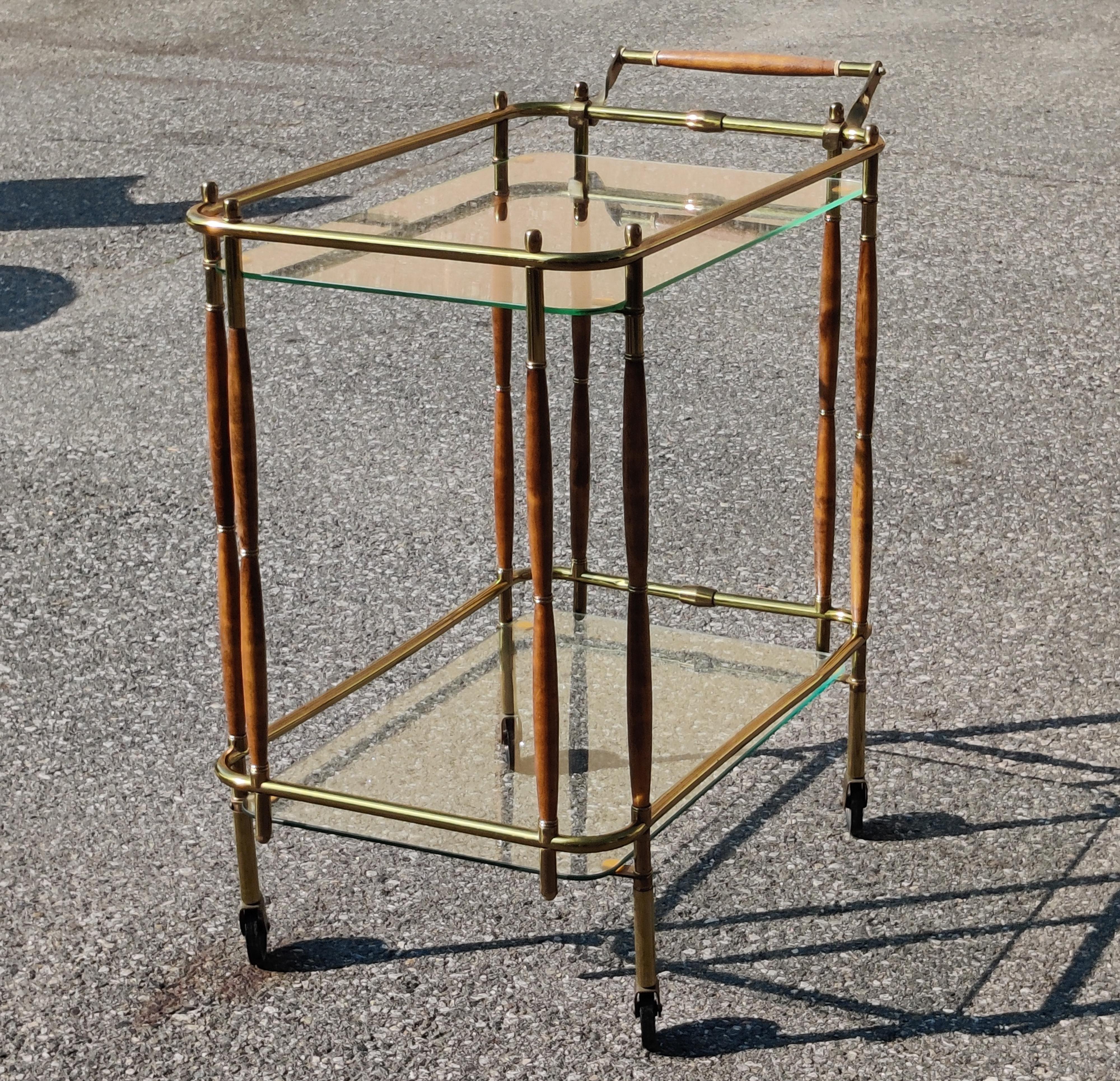 A very elegant Italian style or Hollywood Regency style tubulaur brass bar cart with turned walnut elements. This stylish bar cart is also very practical, having the orignal casters and a handle for ease of use. Notice the gallery around the lower