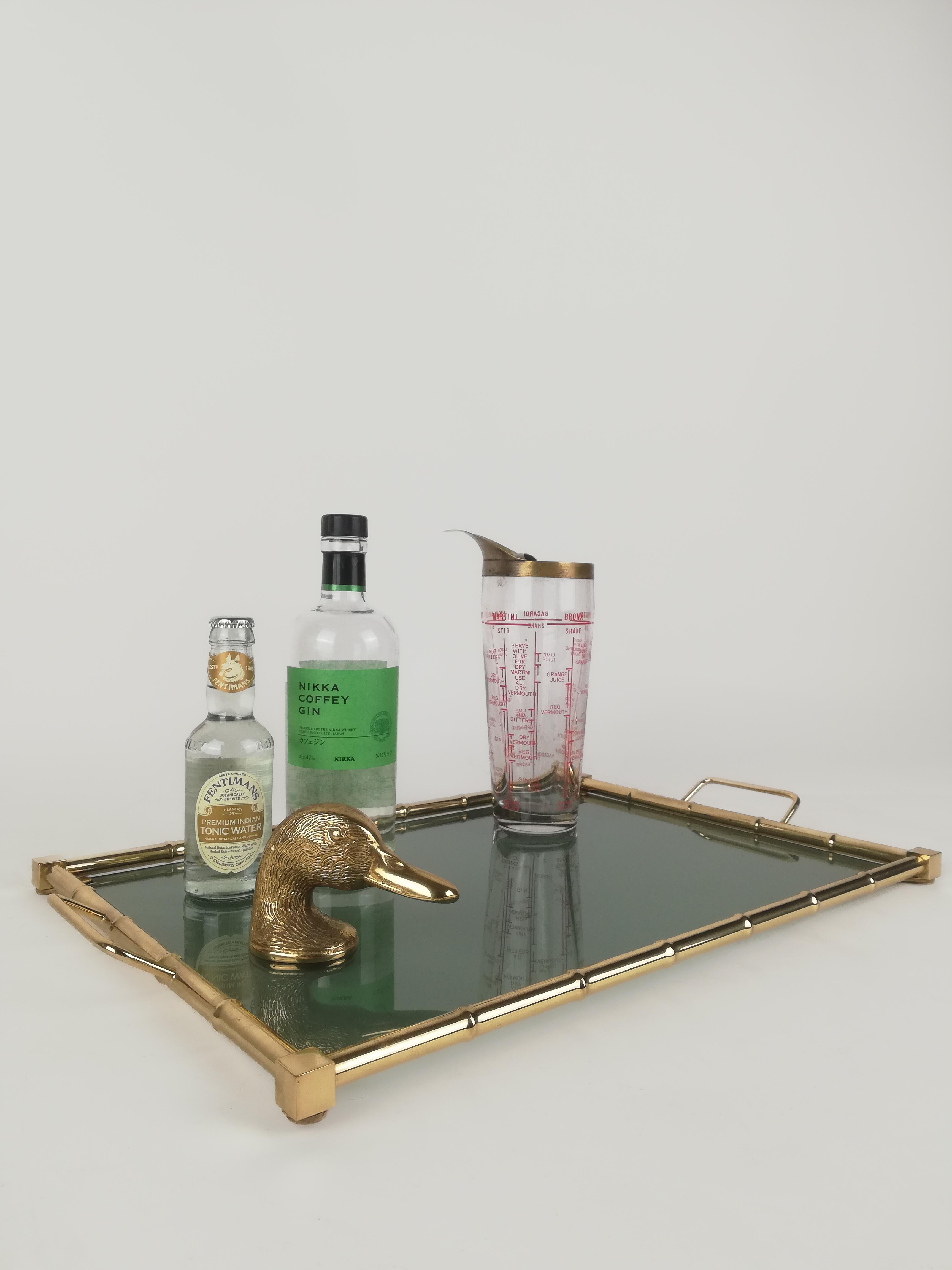 A splendid midcentury golden serving tray, in brass faux bamboo and fumè glass.
This vintage tray is made in Italy, and datable between the 1960s and the 1970s; a functional serving pieces and a perfect glamorous accessory for a Hollywood Regency