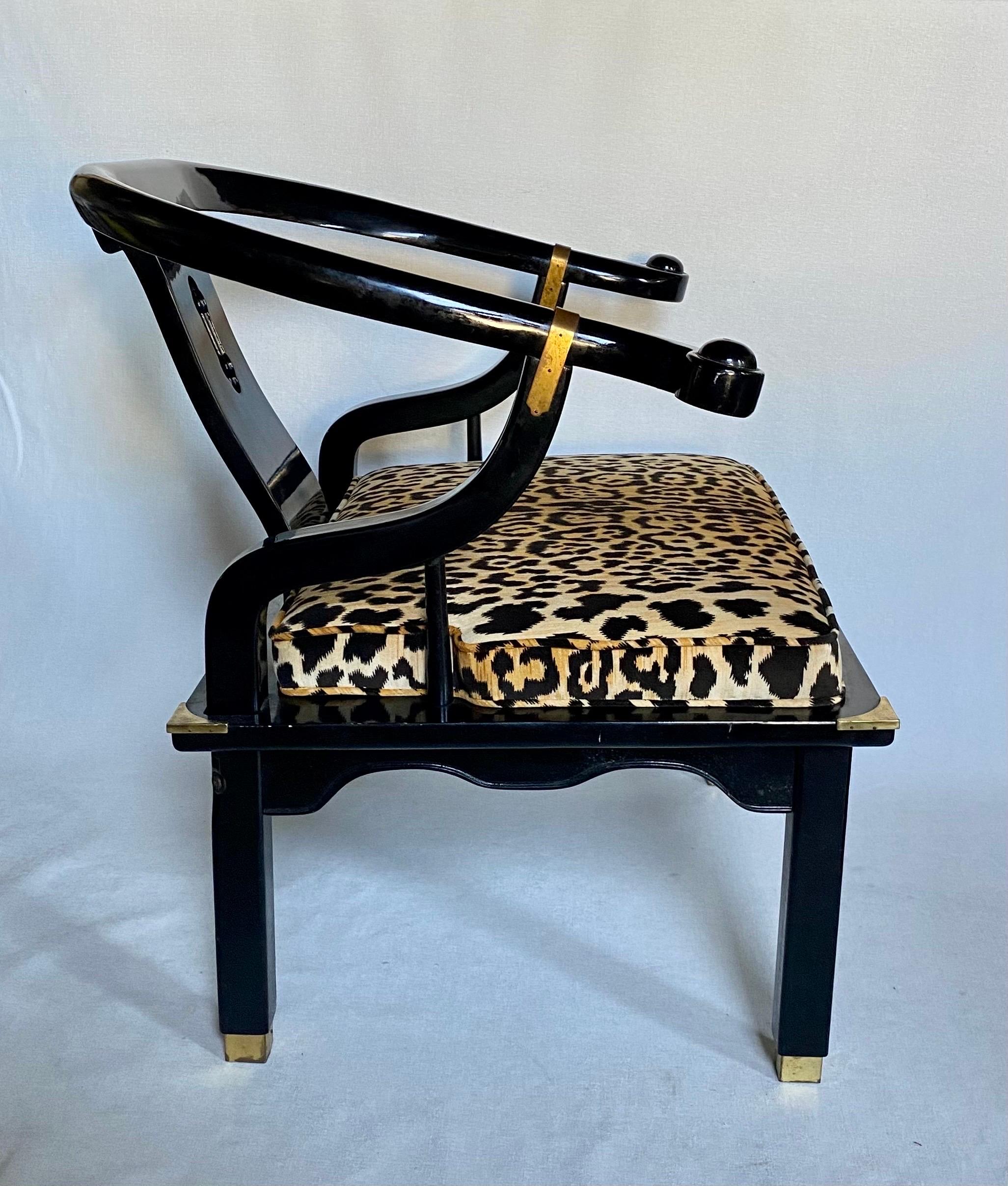 Hollywood Regency style lounge accent chair by Century Furniture. This James Mont style armchair features a gloss black lacquer wood frame with brass hardware accents. Cushion is newly upholstered in a cotton-velvet animal print fabric. 