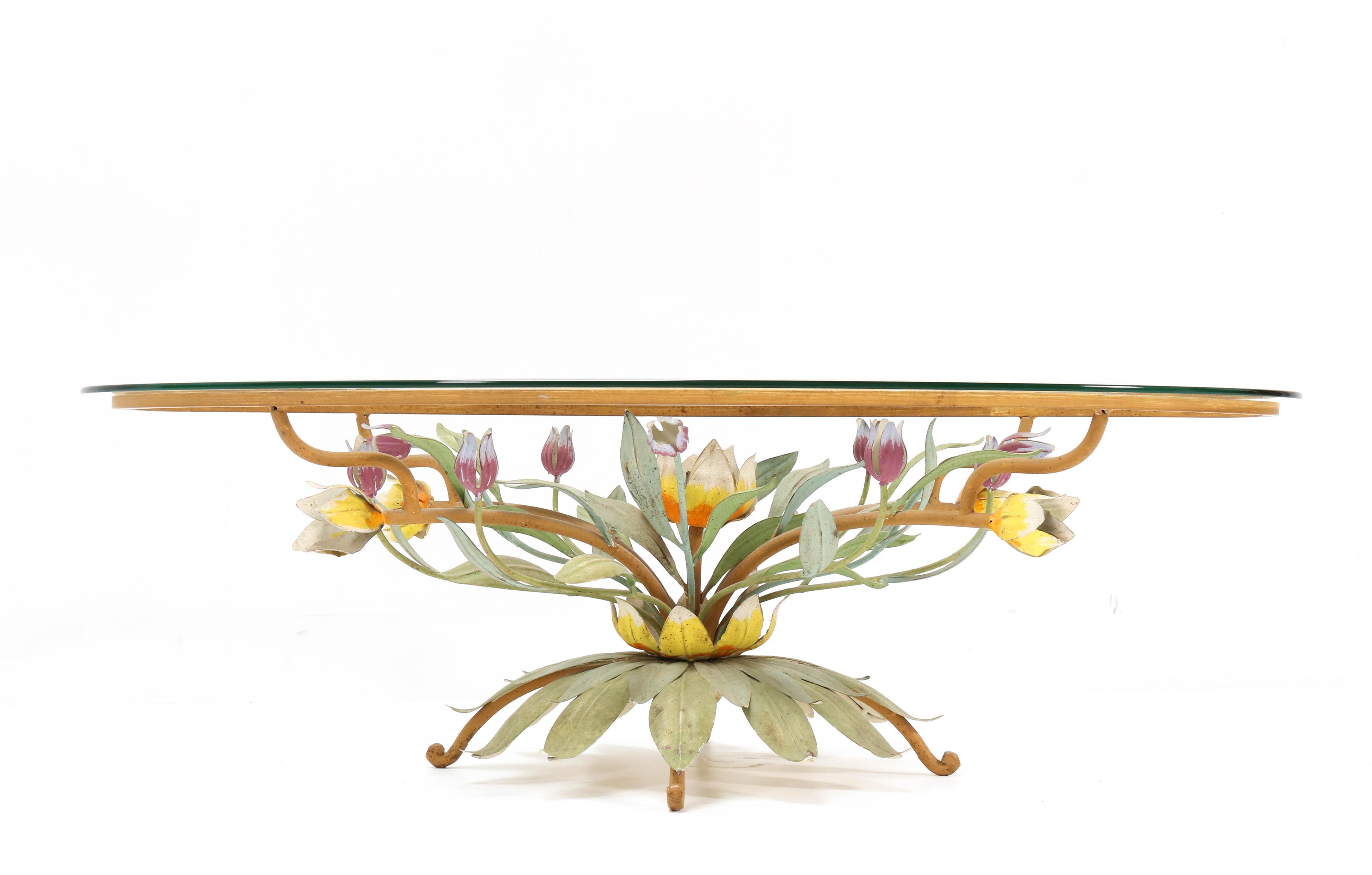 Magnificent and rare Hollywood Regency coffee table.
Striking French design from the 1970s.
Original lacquered metal frame with flowers in various colors.
The original glass top is beveled.
This wonderful piece of furniture is very decorative in