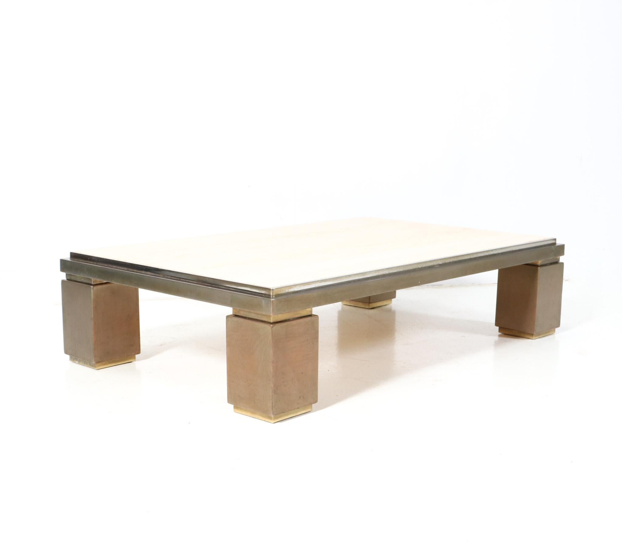 Magnificent and rare Hollywood Regency large coffee table.
Design by Belgo Chrome.
Striking Belgium design from the 1970s.
Original patinated brass frame with original travertine top.
This wonderful Hollywood Regency large coffee table by Belgo