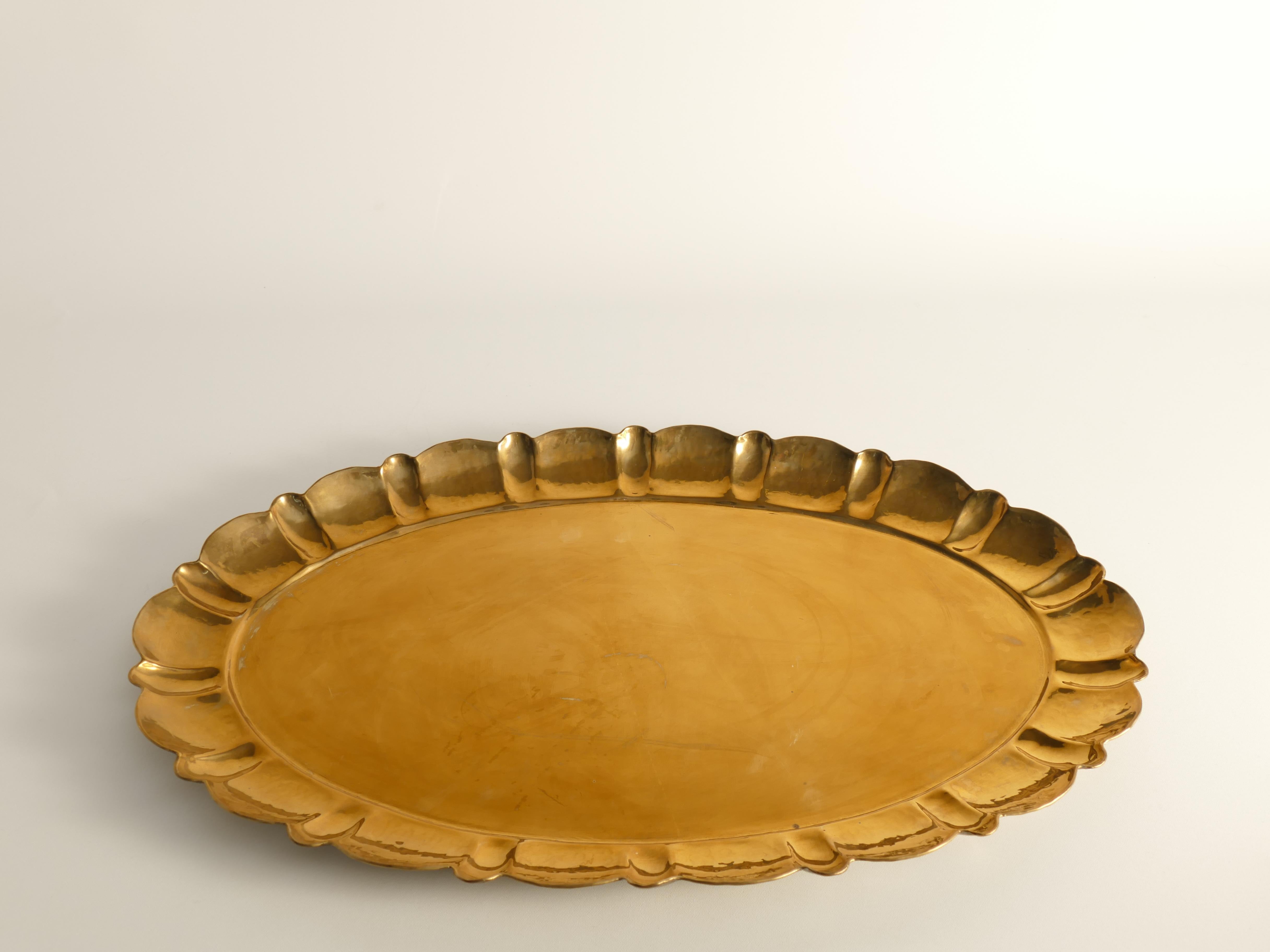 Bandeja de latón magistralmente elaborada, de forma ovalada con un elegante borde contorneado y martillado a mano. Funcionamiento manual y sello de autenticidad. La decoración martillada y el borde perfilado realzan su encanto único. Esta exquisita