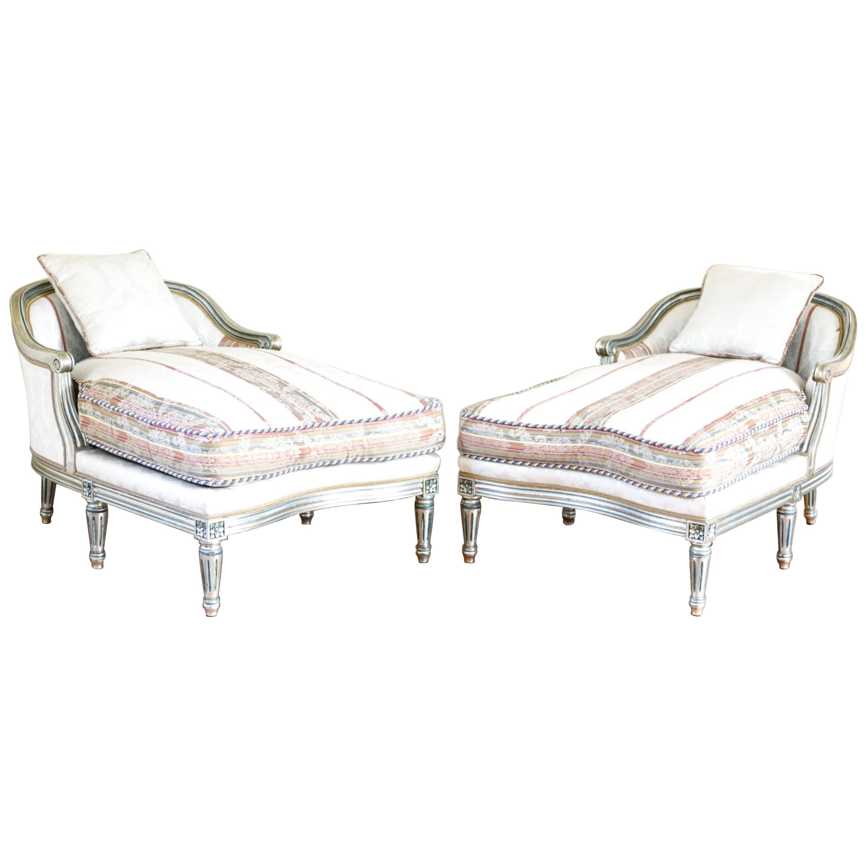 Hollywood Regency Louis XVI style chaise lounges or extended marquees. The pair in a fine French painted and parcel gilt silver decorated frame with an exquisite matching fabric. Having hand silver leaf carved and silver gilt frames these stunning