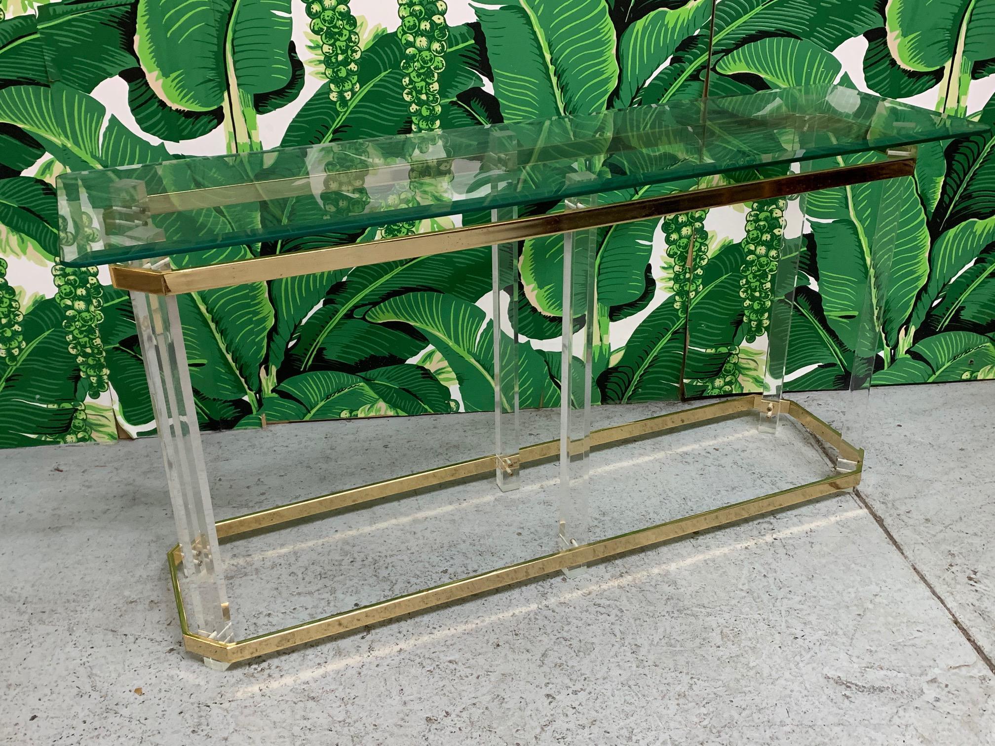 Mid Century console table by Charles Hollis Jones features lucite and brass frame and glass shelf. Perfect addition to any Hollywood Regency decor. Good condition with imperfections consistent with age, see photos for condition details.
 