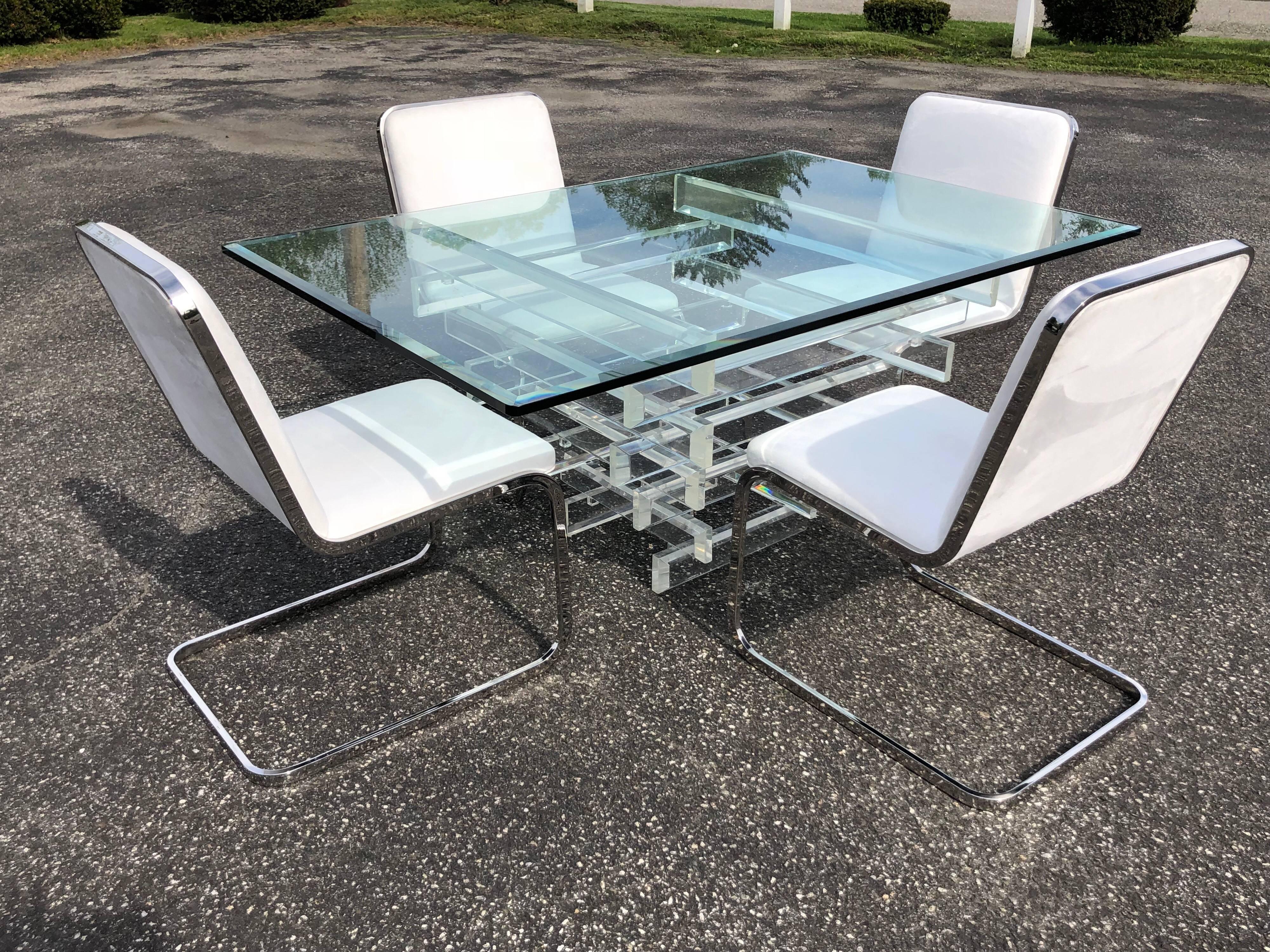 Mid Century Lucite and glass dining table and chairs in the manner of Charles Hollis Jones. Amazing stacked Lucite Helix dining table base with four matching white Ultrasuede and chrome cantilevered chairs. An absolutely stunning set. If you would