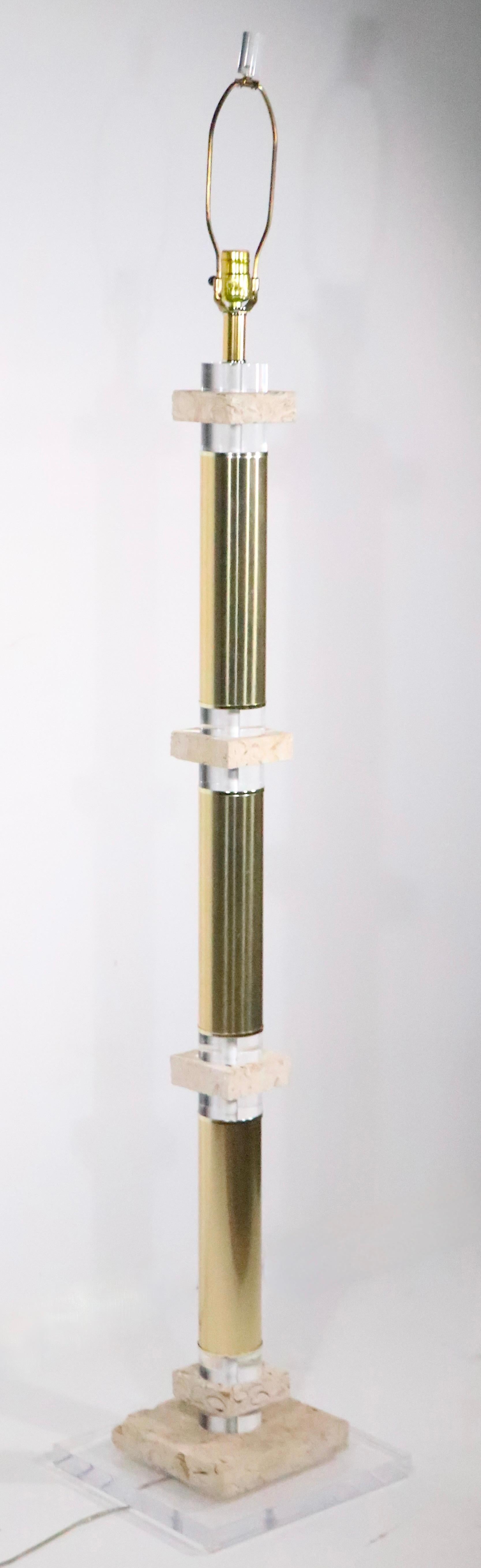 Exceptional Hollywood Florida Regency style floor lamp constructed of tubular brass with cast lucite and fossilized stone spacers. The lamp is in very fine, original, working,  clean and ready to use condition. The lamp retains it's original shade,