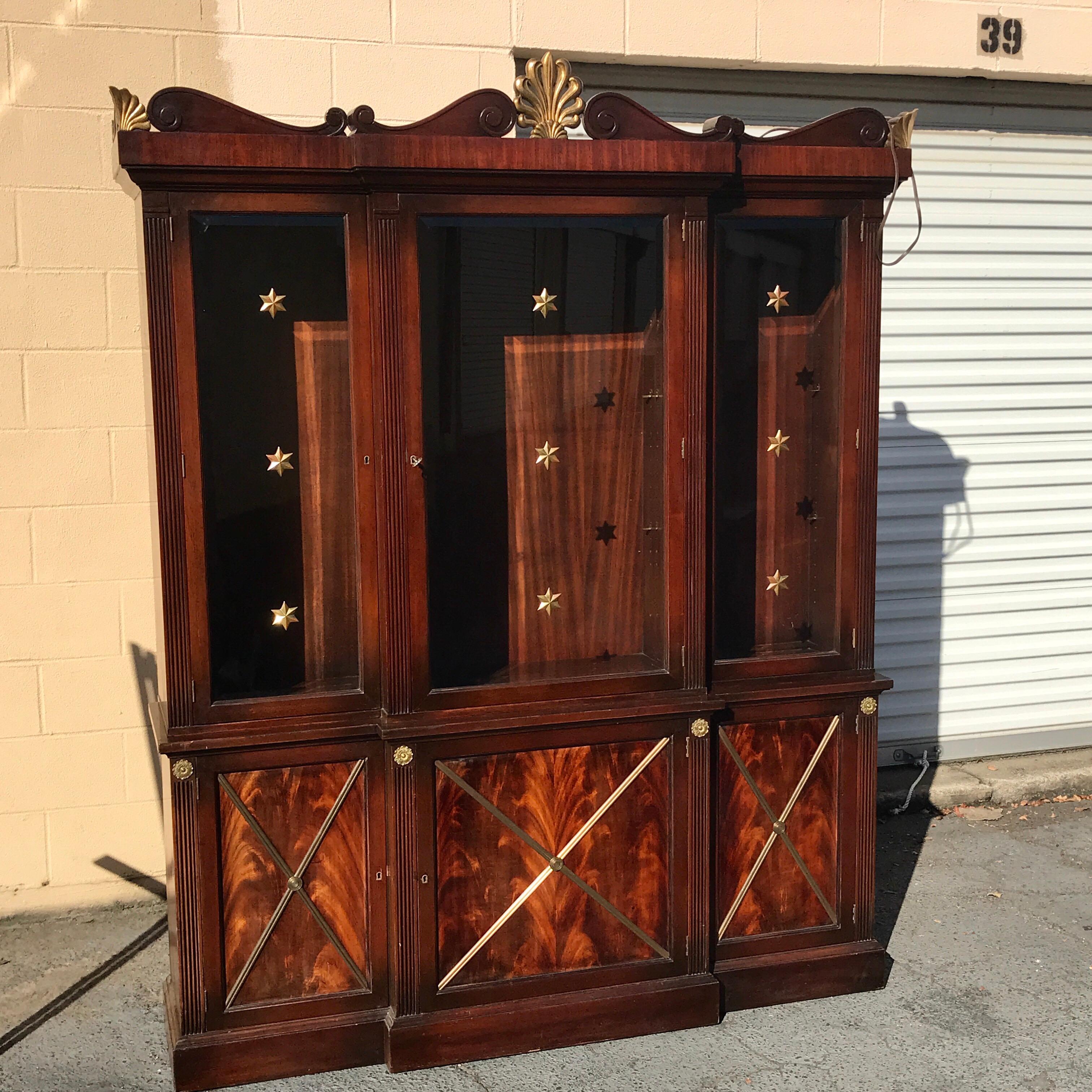 Hollywood Regency mahogany breakfront or bookcase, with nine applied gilt brass stars on the three glass doors, the flanking cabinets measure 15