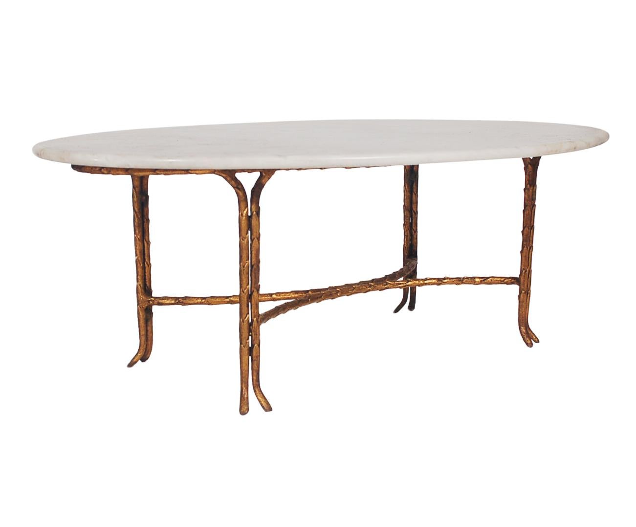 A gorgeous and sophisticated coffee table attributed to Maison Baguès, circa 1960s. It features a heavy gold gilt bronze table base with white marble oval top. Very well cared for condition.
