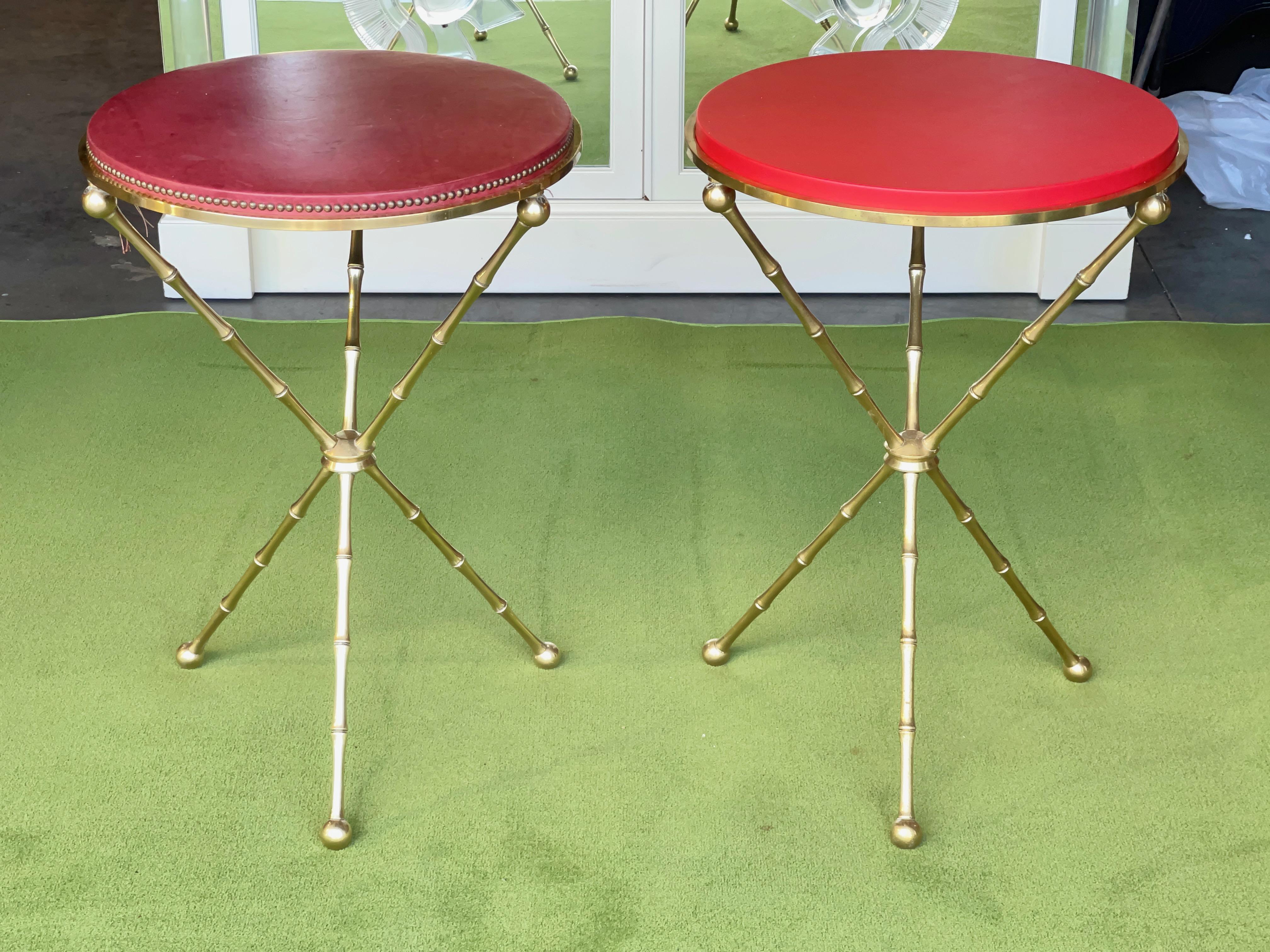 This is the table that launched a thousand imitators. 
Pair of solid brass bamboo-form tripod tables with fixed brass ring into which is inset a leather covered wood top 1.25
