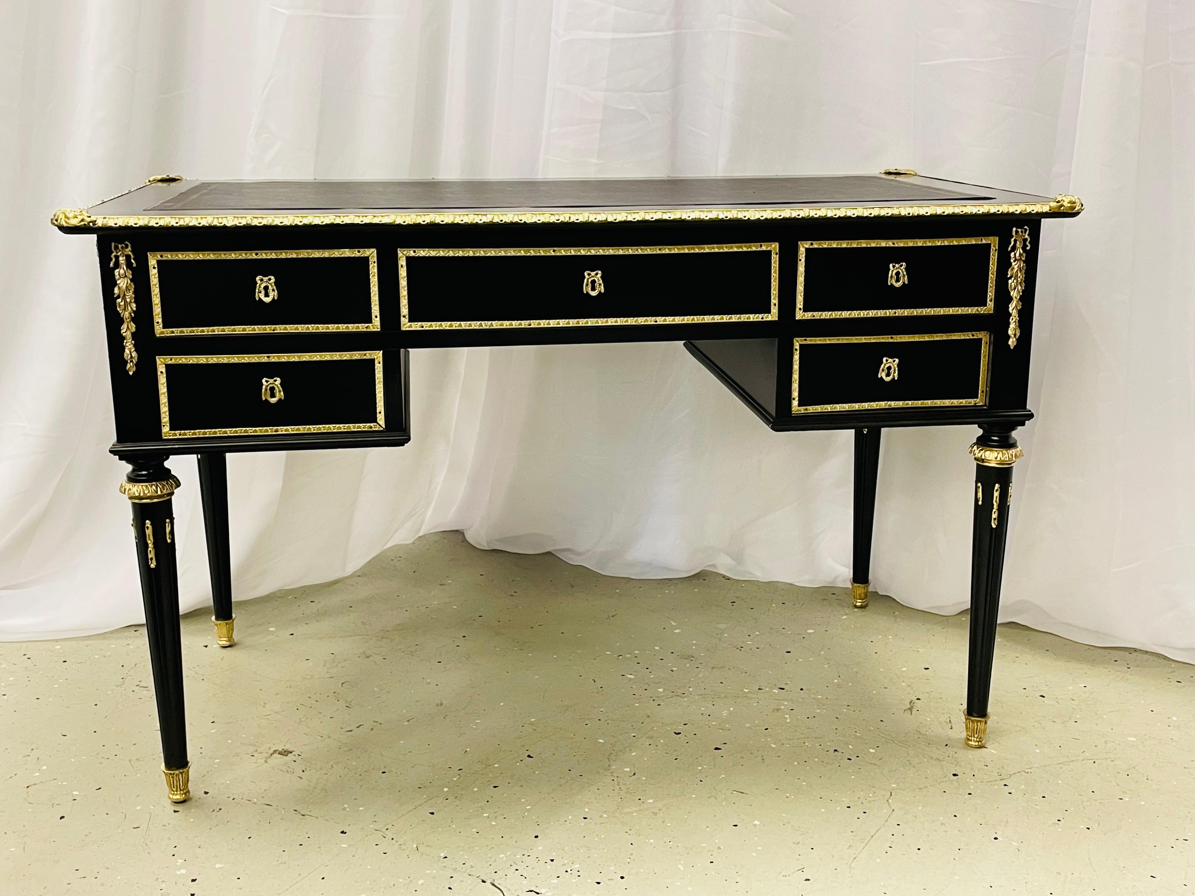 A Hollywood Regency ebony and bronze mounted desk, writing table or vanity

A stunning example of this highly sought after designers work. Bronze sabots and capitals shine on the sleek tapering legs with flame bronze mounts on the reeded centers