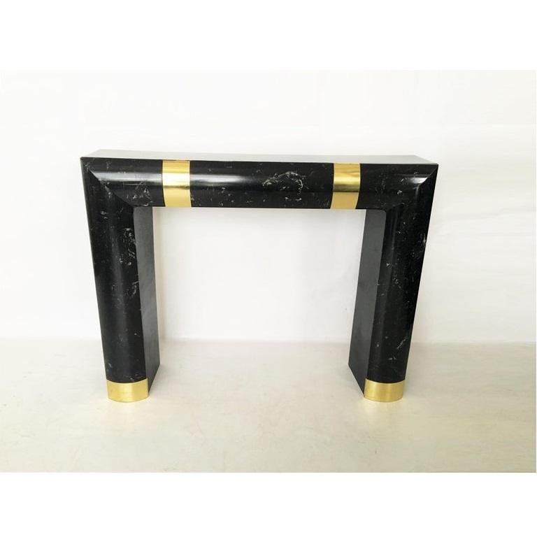 Vintage Hollywood Regency fireplace surround in the style of Karl Springer. Made of marble with brass details. 
Overall mantel dimensions: 42 in. H x 52.5 in. W x 11 in. D
opening dimensions: 35 in. H x 38.75 in. W x 10.5 in. D.