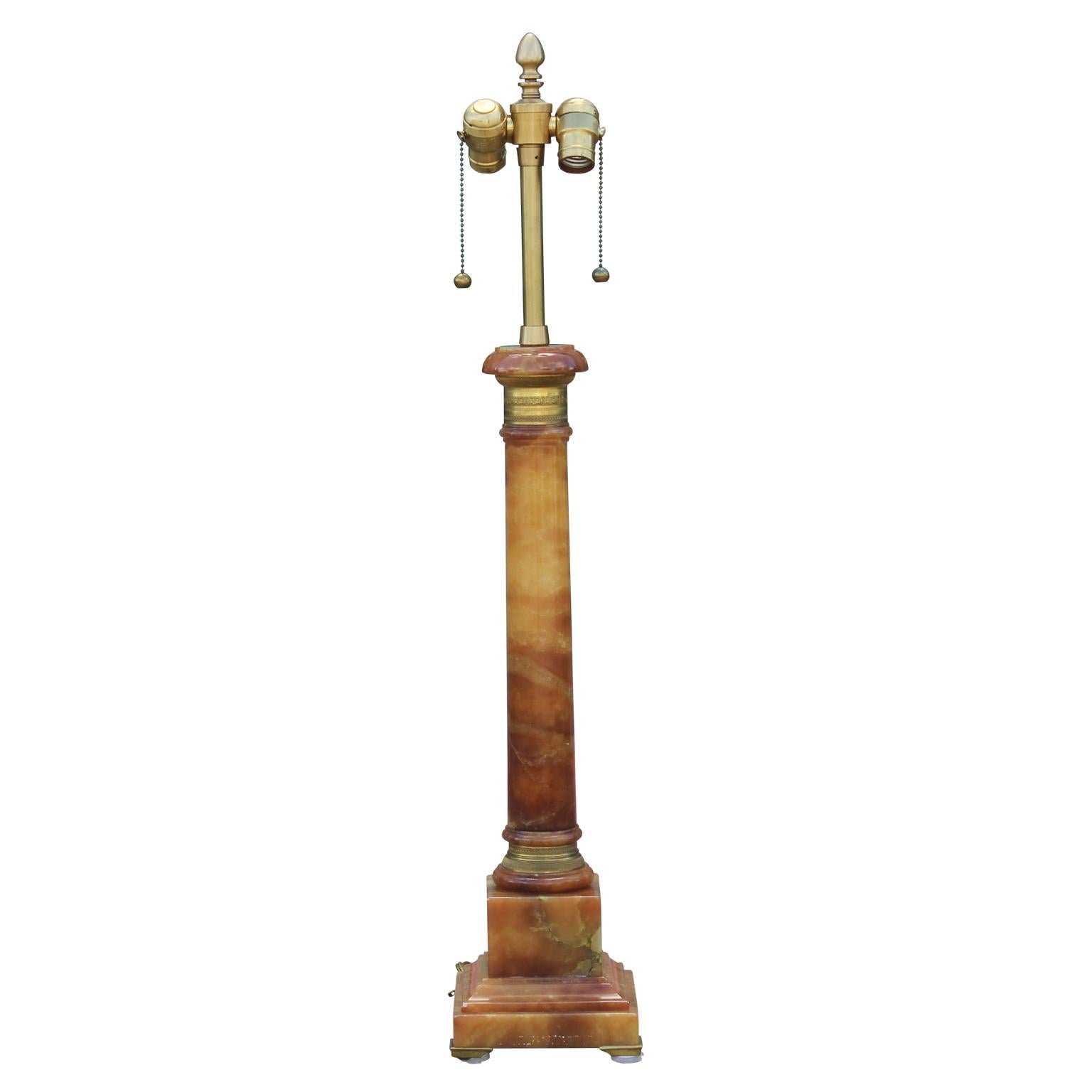 Gorgeous single Hollywood Regency onyx and brass table lamp with two light sockets and brass chain pulls.