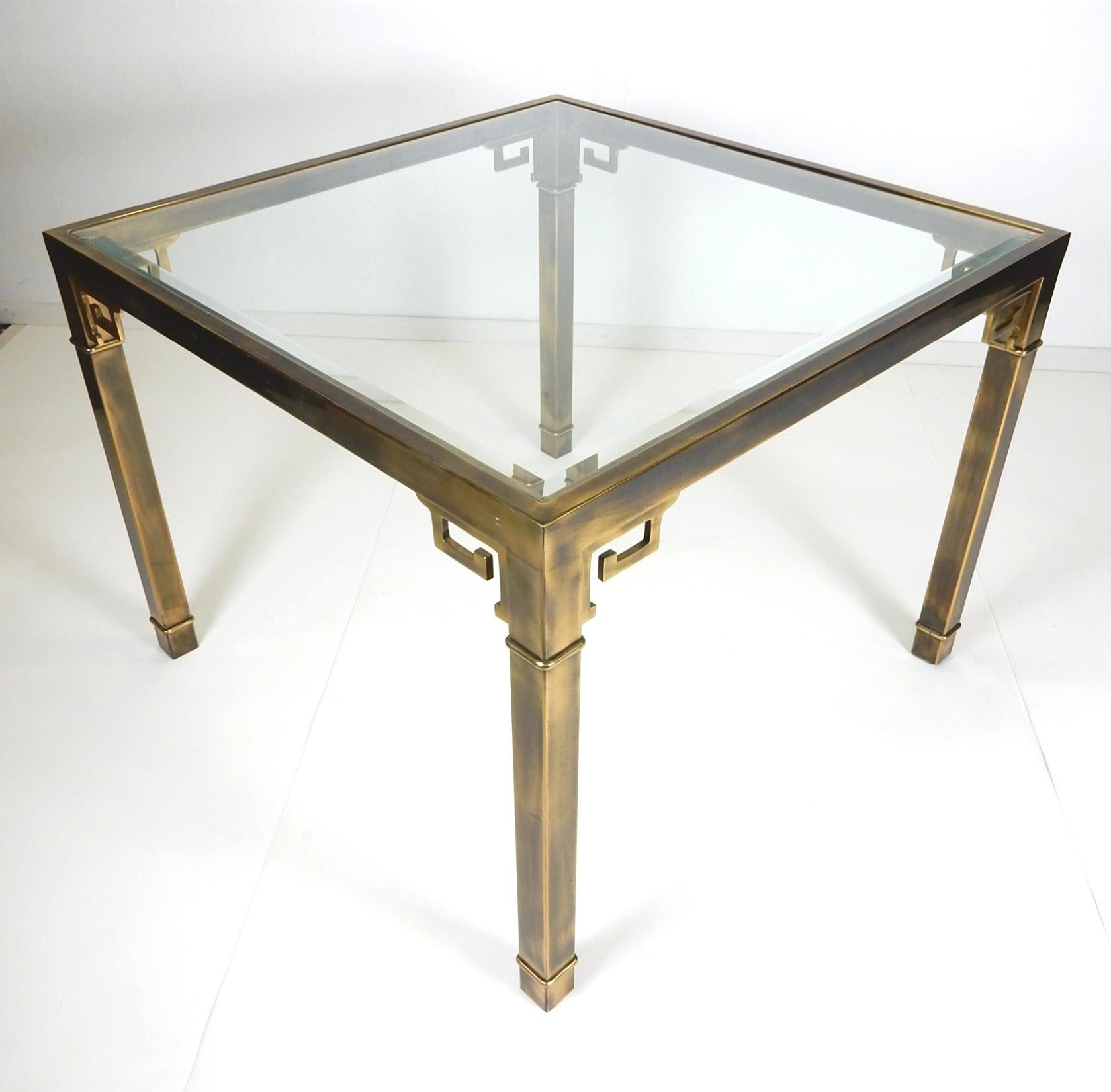 Rare square game table by Mastercraft Furniture, circa 1970s.
Brushed patina'd brass finish with Greek key design.
Inset glass top. Measures: 38 inch square, 29 inch tall.
  