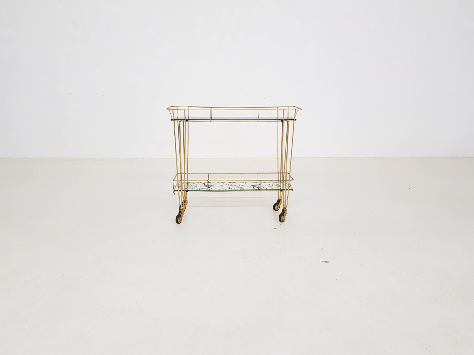 Metal, gold painted trolley or bar cart with decorated glass shelves by Erdecor, France, 1950s.

Cart is in good vintage condition with some traces of use to the gold paint and glass.

Measures: Length 69 cm
Depth 22 cm
Height 61 cm.