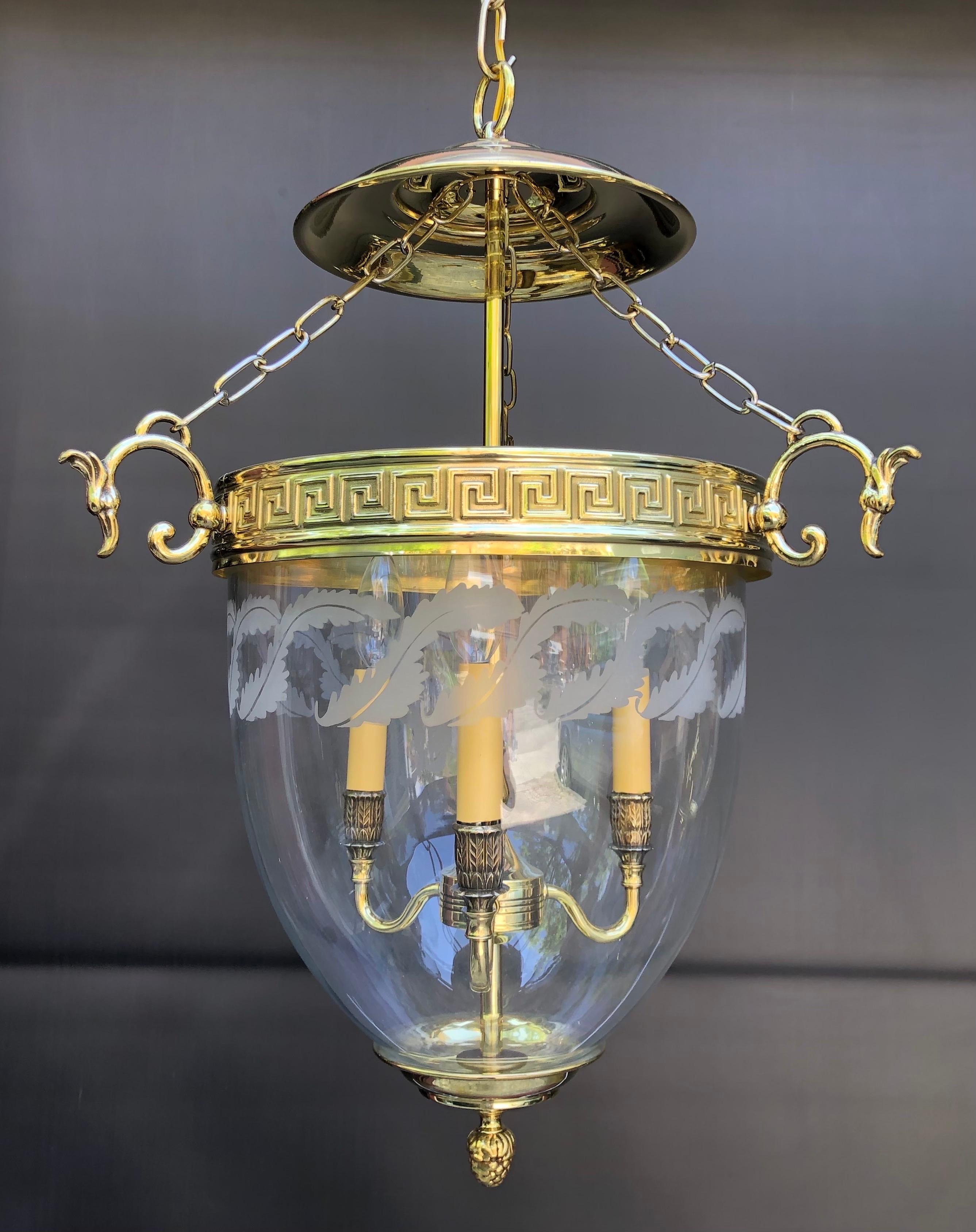 Hollywood Regency mid 20th century bell jar lantern. This high style Bell Lantern has a brass smoke bells with 3 brass chains descending to the Greek Key Band. The chains are hooked to the three Ho Ho Bird scrolled arms. The Hand Blown Glass Bell