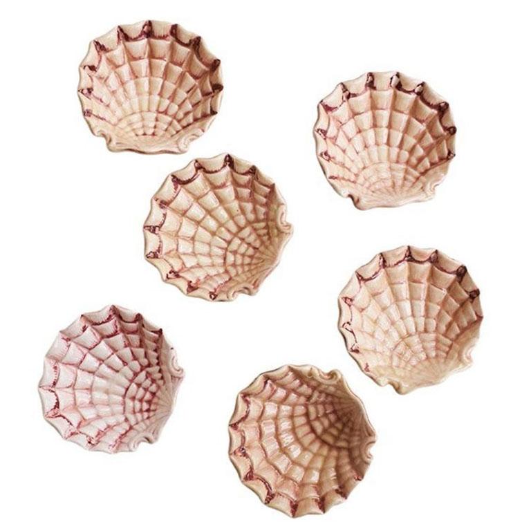 A set of six small ceramic oyster shell motif bowls. This regency-style set of dishes will add interest to any table setting. Use them as bowls for dipping sauces, and dips, or even as a trinket dish or catch-all on a nightstand or bedside table.