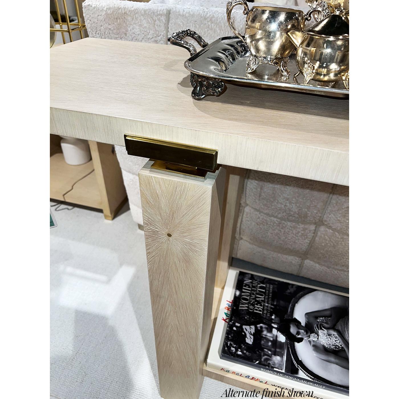 Minimalist Console in a dark mink finish exemplifies this ethos with sculptural clarity. Meticulously artisan made, its bold architectural frame features clean lines, block-style legs, and an open lower shelf for elegant display.

Polished brass