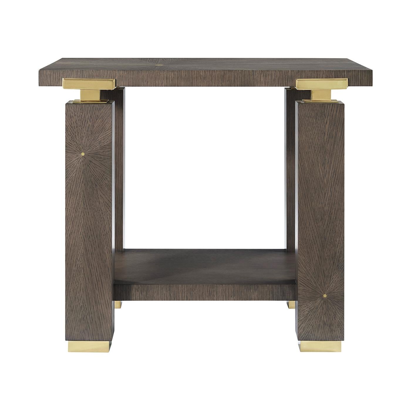 Fabriqué méticuleusement de manière artisanale, son cadre architectural audacieux présente des lignes épurées, des pieds en forme de blocs et une étagère inférieure ouverte pour une présentation élégante.

Les détails en laiton poli ajoutent une