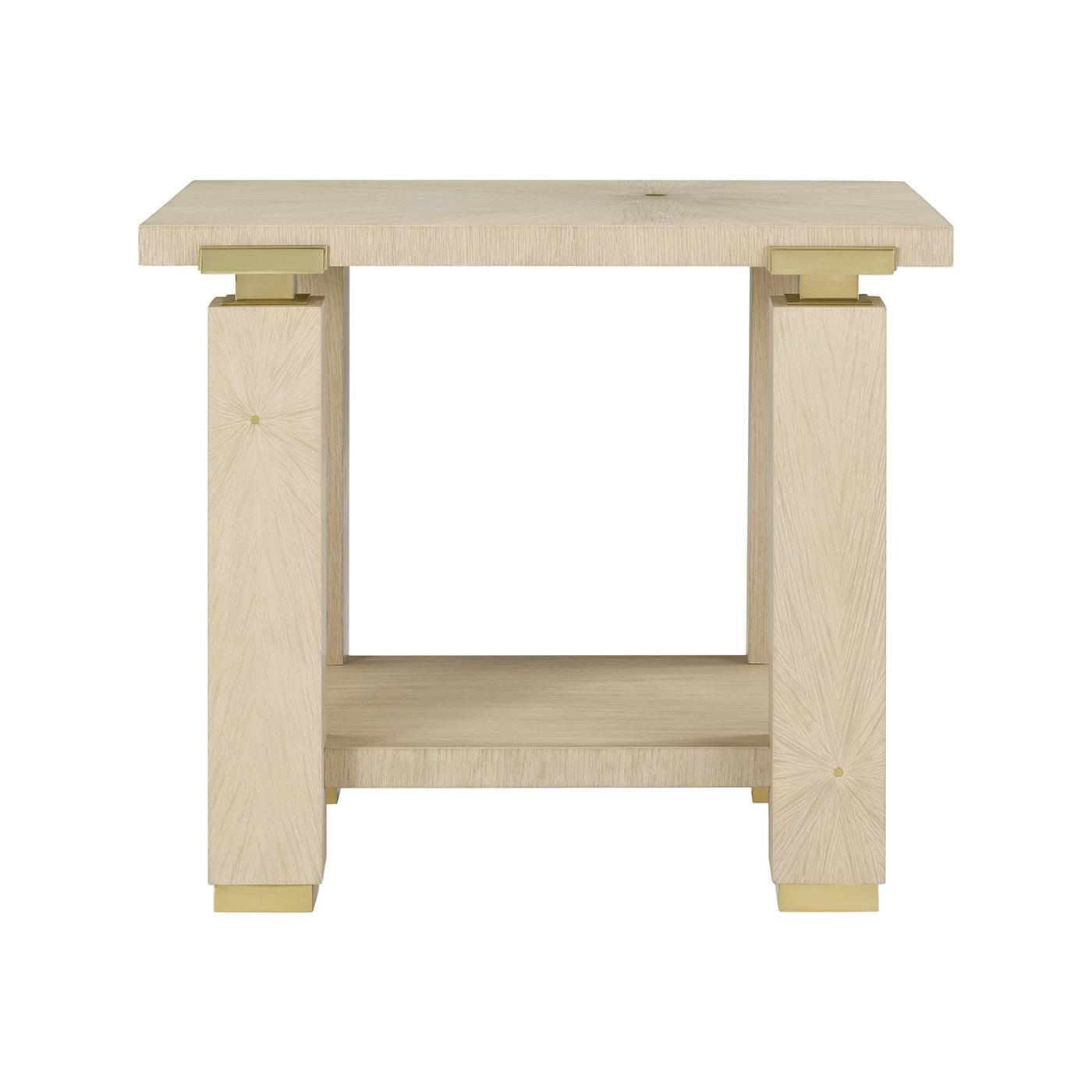 Meticulously artisan made, its bold architectural frame features clean lines, block-style legs, and an open lower shelf for elegant display.

Polished brass detailing adds a touch of tailored glamour, perfectly complementing the natural warmth of