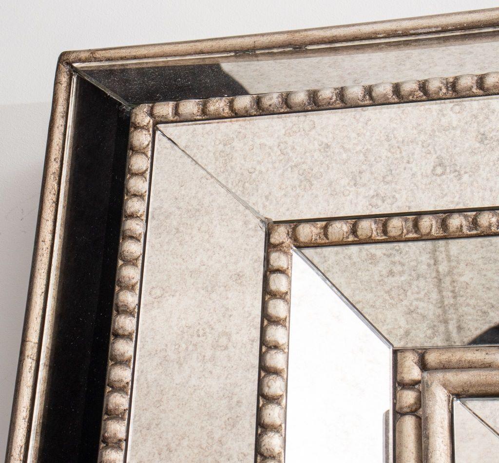 Hollywood regency manner platinum leaf and antiqued mirror cabinet, the frame carefully molded and faceted with mercury mirror panels, centering a clear mirror plate, opening to reveal a black velvet lined interior fitted for earrings, necklaces,