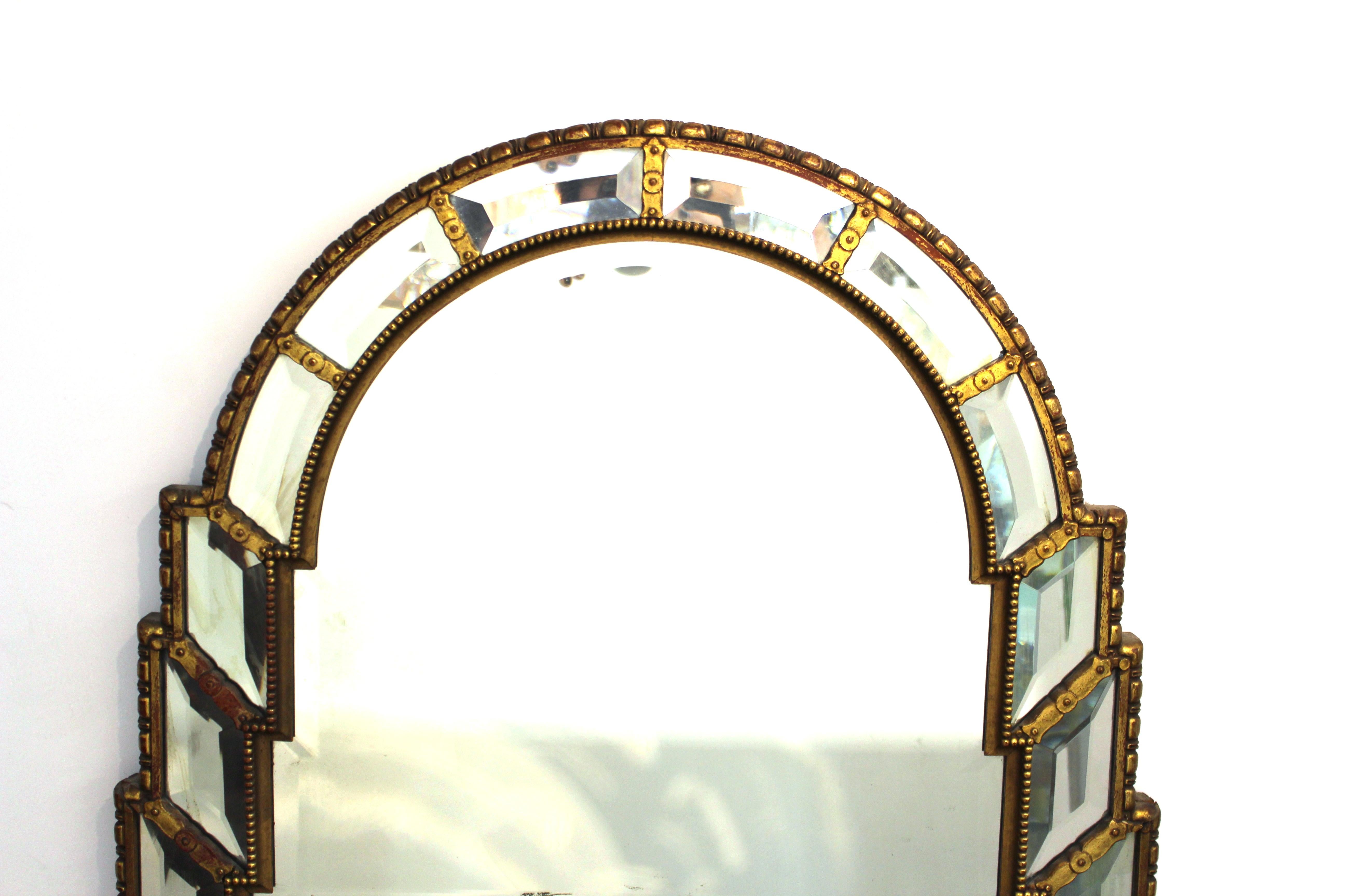 Hollywood Regency wall mirror with elaborate giltwood mirror frame. The piece is in great vintage condition with age-appropriate wear.