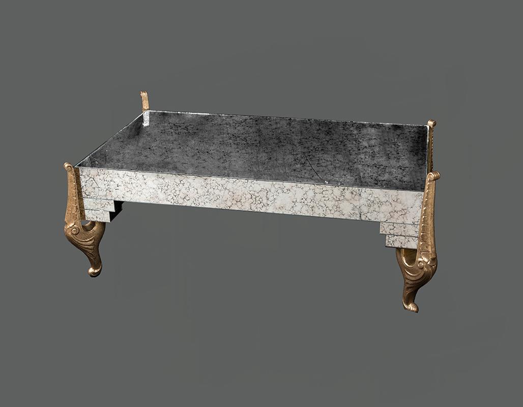 Rectangular antiqued mirrored coffee table gilded carving wood leaf legs, Hollywood Regency style. The four carving wood table legs have two different heights of the curl.
 