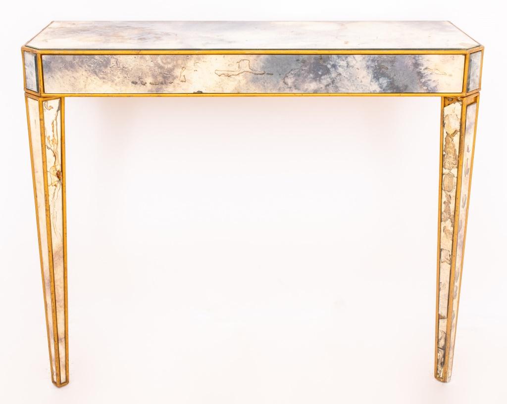 Hollywood Regency mirrored parcel-gilded console, chamfered rectangular with tapering rectangular legs, the top, sides, and legs paneled with antiqued mirror, possibly Italian, 1960s.

Dimensions: 31