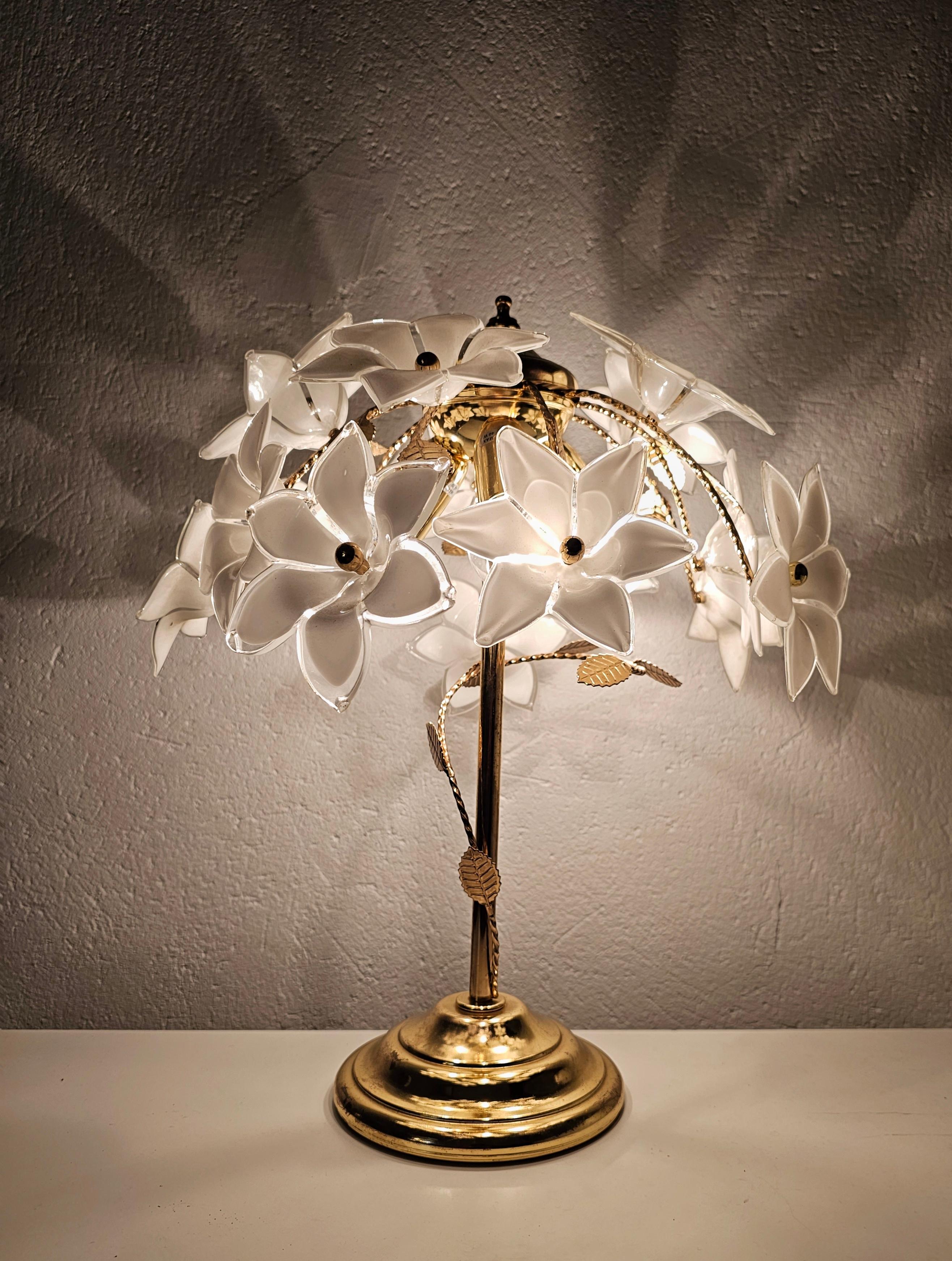 Cette annonce présente une magnifique lampe de table moderne du milieu du siècle, qui a été fabriquée à Murano, en Italie. Whiting comprend le support plaqué or avec des ornements floraux et 15 fleurs de frangipanier en verre de Murano blanc et