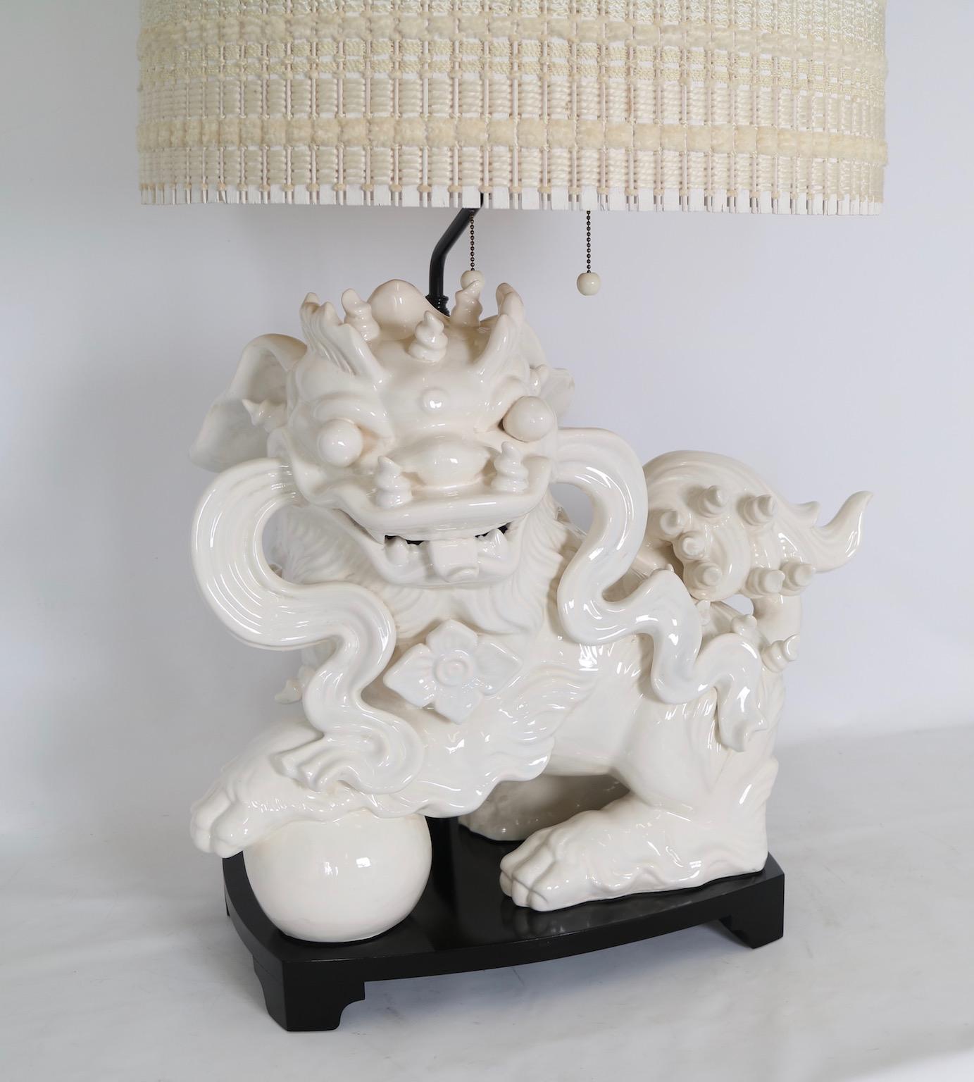 Large Hollywood Regency foo dog table lamp by Nardini Studios in white ceramic. The lamp comes with a textured off-white Maria Kipp shade. The lamp is fully restored with new wiring. This piece is in excellent vintage condition and has wear