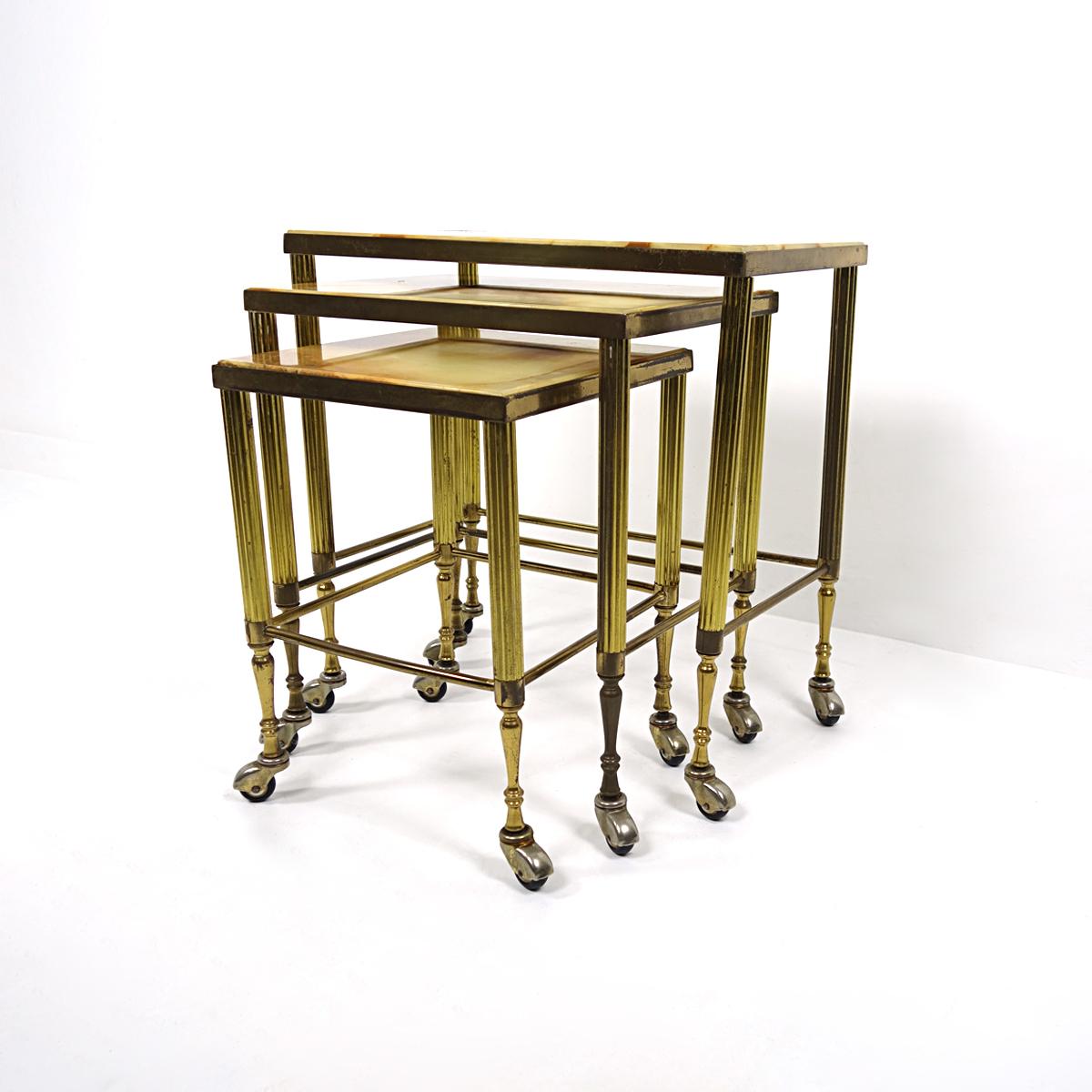 The design of this set of 3 Hollywood Regency nesting tables was clearly inspired by the iconic furniture the famous Paris based company Maison Jansen made. Their weight, looks and smoothly running wheels make the tables exude lots of grandeur. The