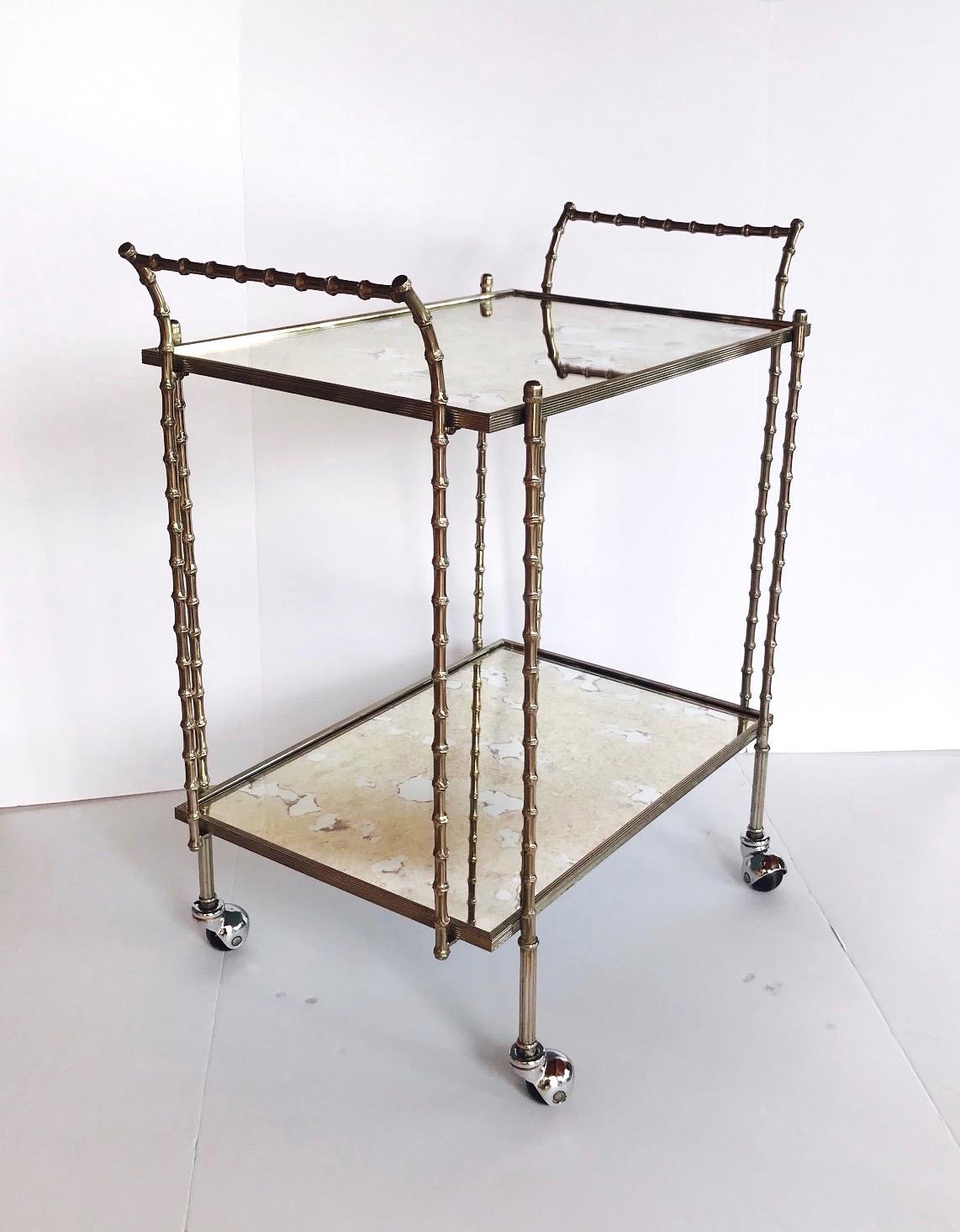 Elegant French Hollywood Regency bar cart with bamboo motif. The trolley has two tier design comprised of silvered or nickel over solid brass metal. Fitted with two mirrored tops with a smokey bronze antique finish. The cart features curved side