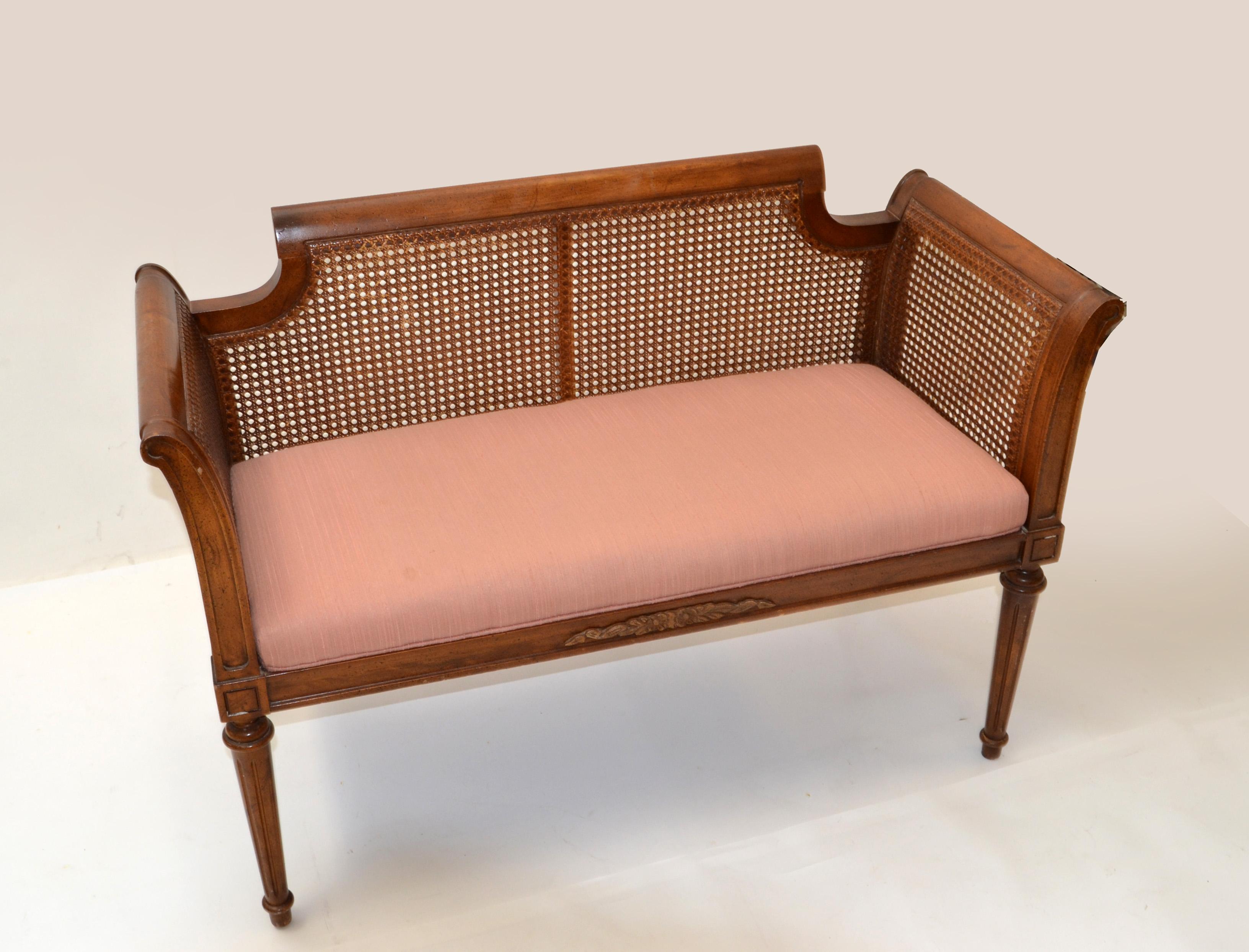 American Hollywood Regency classic bench with peach cotton Seat Upholstery.
All around woven caning frame and a sturdy base with turned wooden legs and carved lines for Decor.
Great clean line design.
In all good condition with some normal wear
