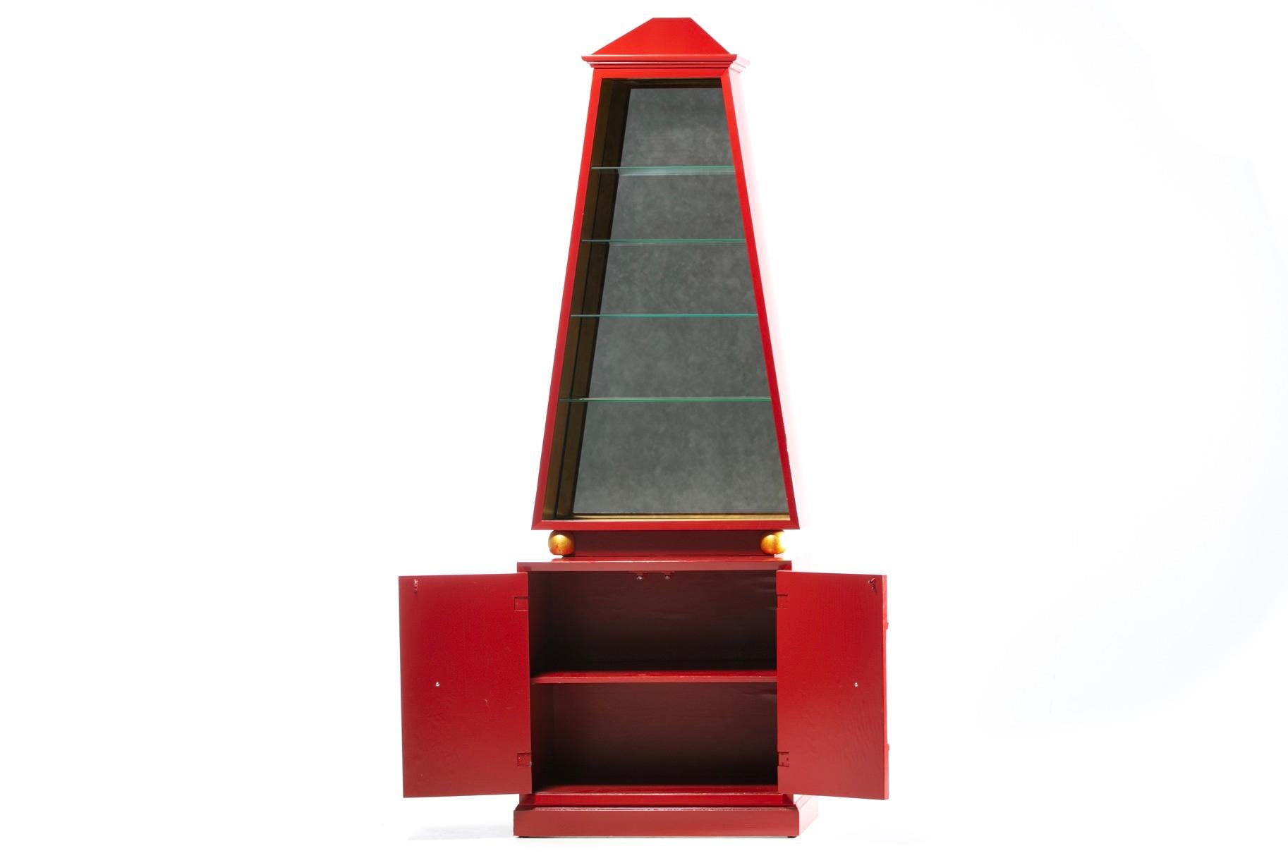 Vetro Cabinet Obelisco Hollywood Regency rifinito in lacca rossa e foglia d'oro del 1960 circa in vendita