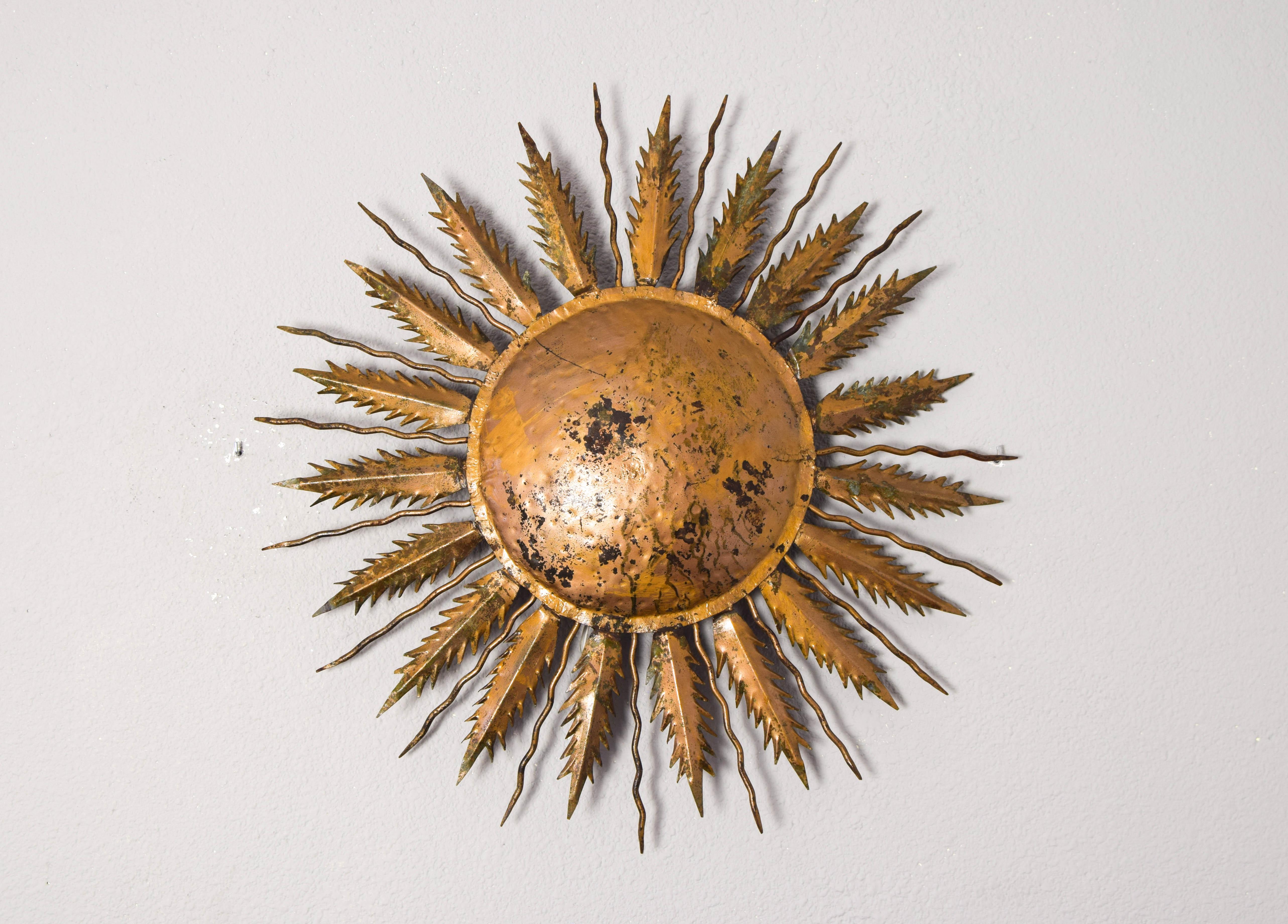 Large Flush Mount in hammered metal in the shape of the sun.
Wall light manufactured by hand and finished in gold leaf by Ferroarte Spain in the decade of the 40s.
With the passage of time, it has incorporated obvious signs of loss in its gilding
