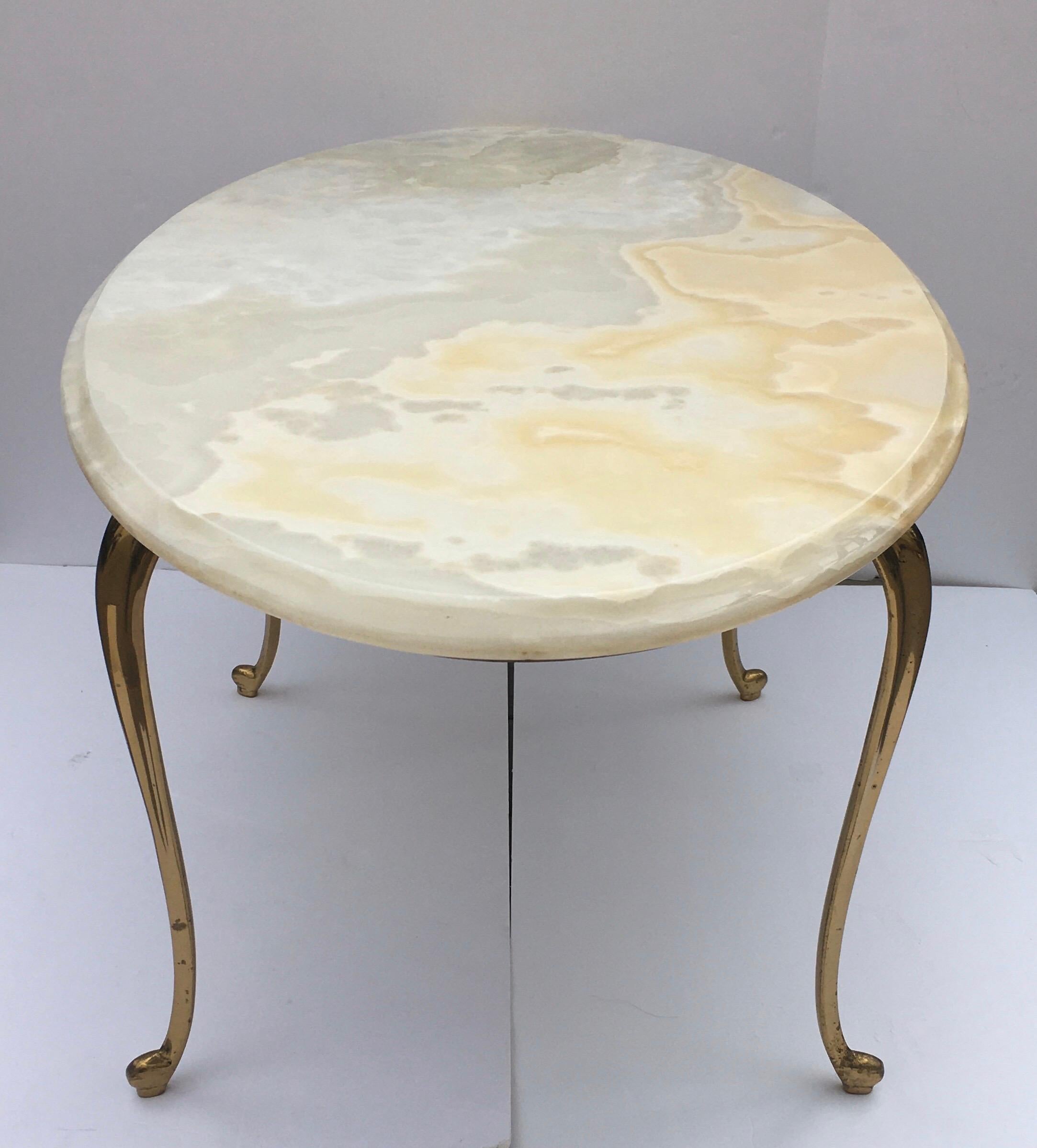 Italian midcentury Hollywood Regency oval shaped cocktail coffee table featuring a beveled onyx stone top and curved cabriole polished brass legs.
