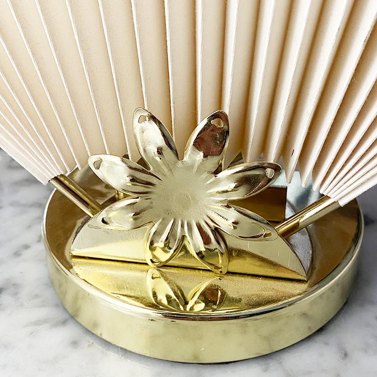 Abstract, Mid-Century Modern, chinoiserie or Hollywood Regency style cream or off white accordion fan table lamp with gold floral motif. Reminiscent of Caprani style lighting, this beautiful cream fan is a statement piece that blurs the lines