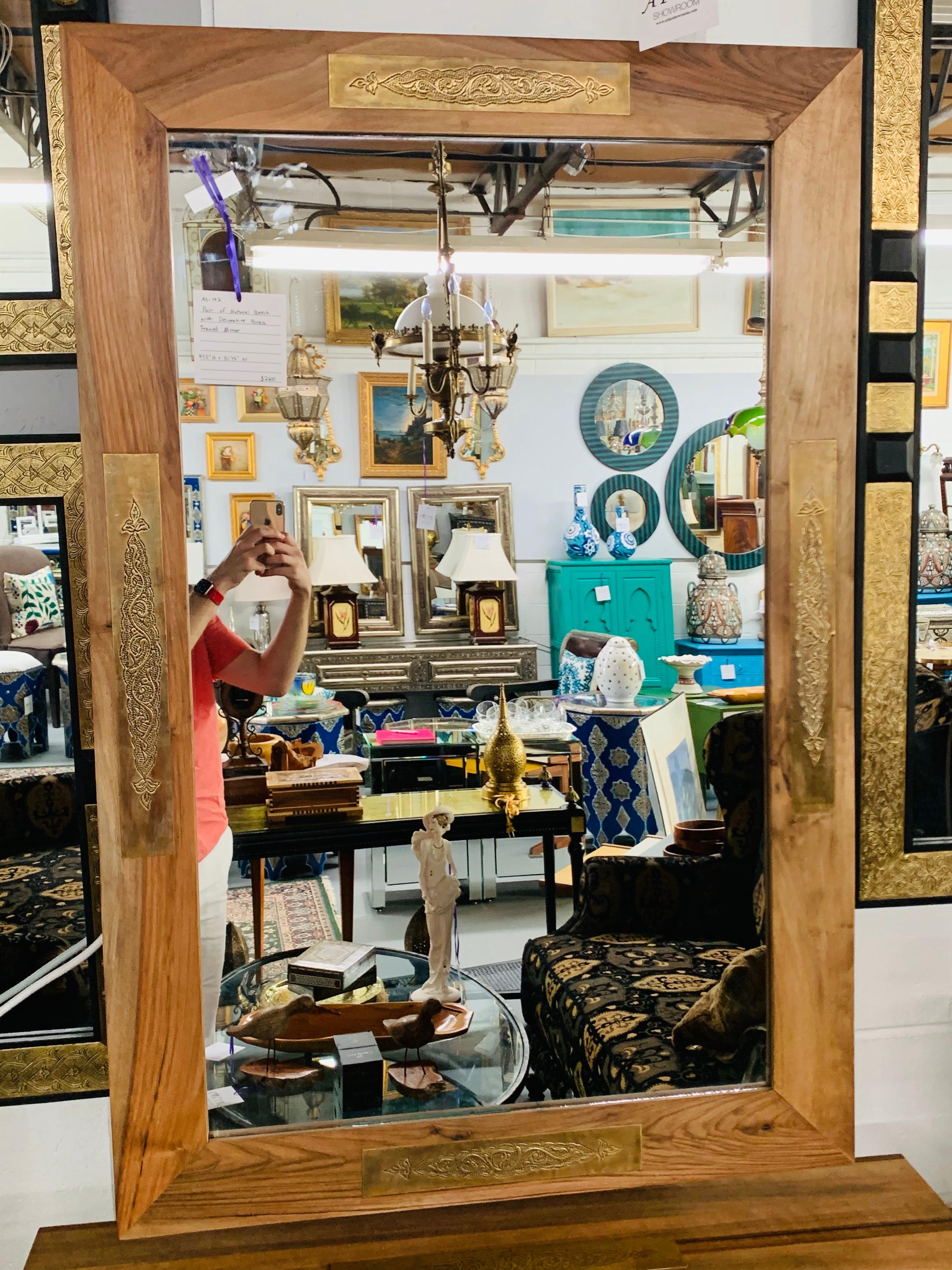 This pair of Hollywood Regency Organic mirrors are made of walnut and feature four pieces of rectangular brass of filigree motifs adding a touch of elegance. A beautiful addition to any living environment and design. The intricate brass hand chased