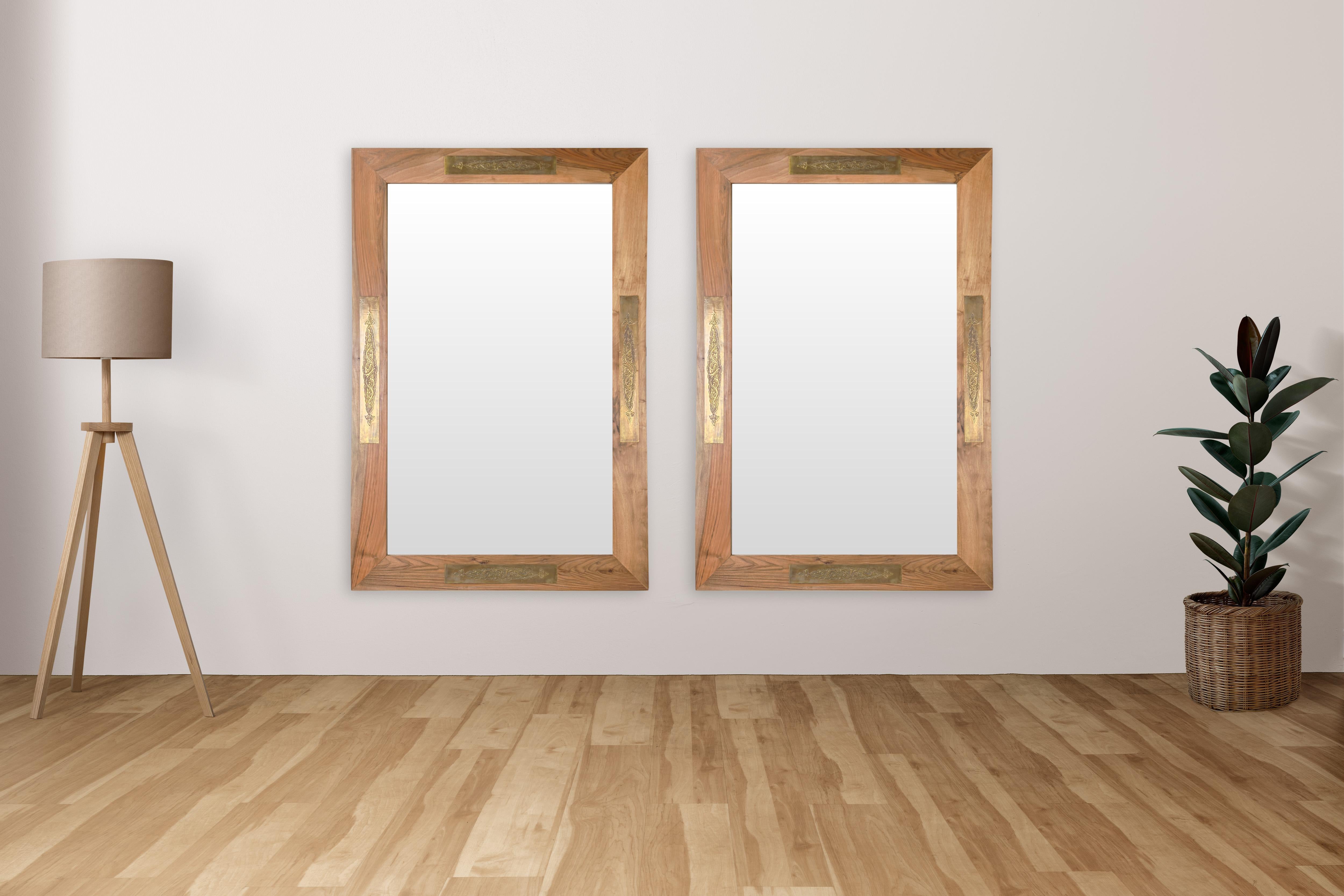 Questa coppia di specchi Organic Modern realizzati a mano cattura l'essenza della sobria eleganza, fondendo materiali naturali con sottili tocchi ornamentali. Realizzata in noce, la cornice emana calore e semplicità organica, lasciando che le