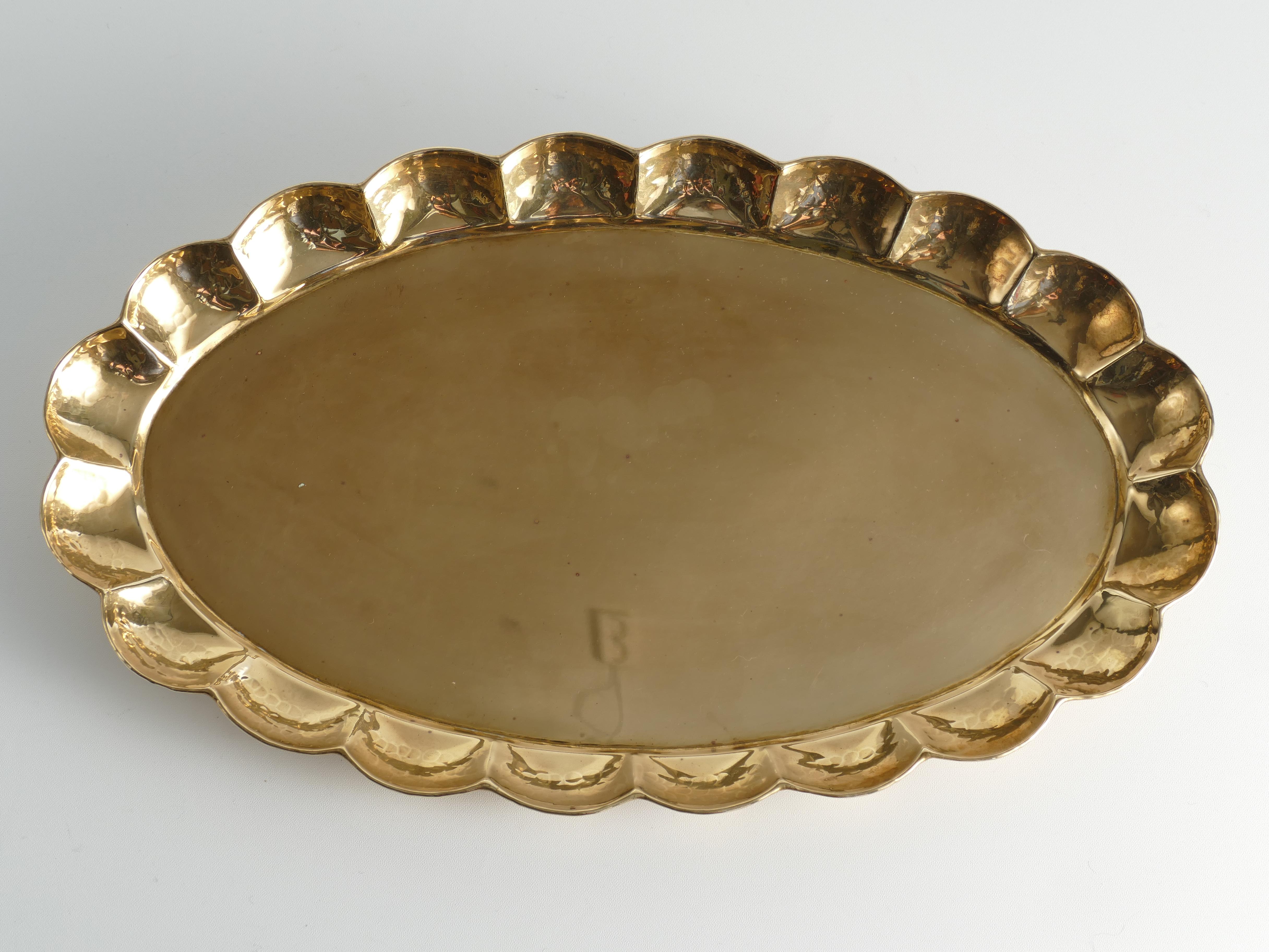 Meisterhaft gearbeitetes ovales Messing-Tablett im Art-Deco-Stil, entworfen von Arvid Johansson (1862-1923) und hergestellt in Karlstad Konstsmide, Schweden. Das Tablett hat eine ovale Form mit einem anmutig konturierten, handgehämmerten Rand.
