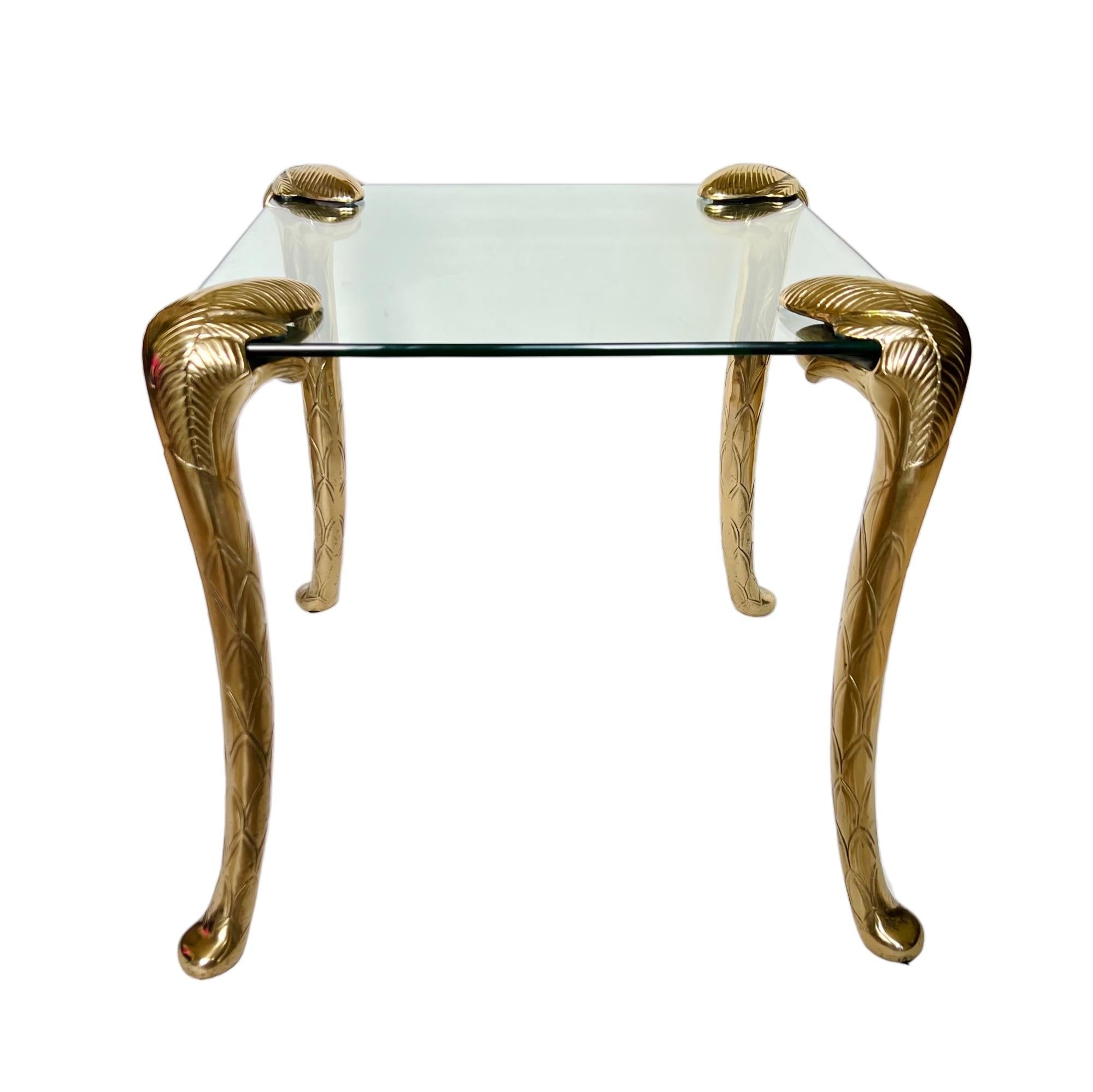 A vintage Hollywood Regency brass and glass side table in the style of Maison Jansen and P.E. Guerin. It features a square 