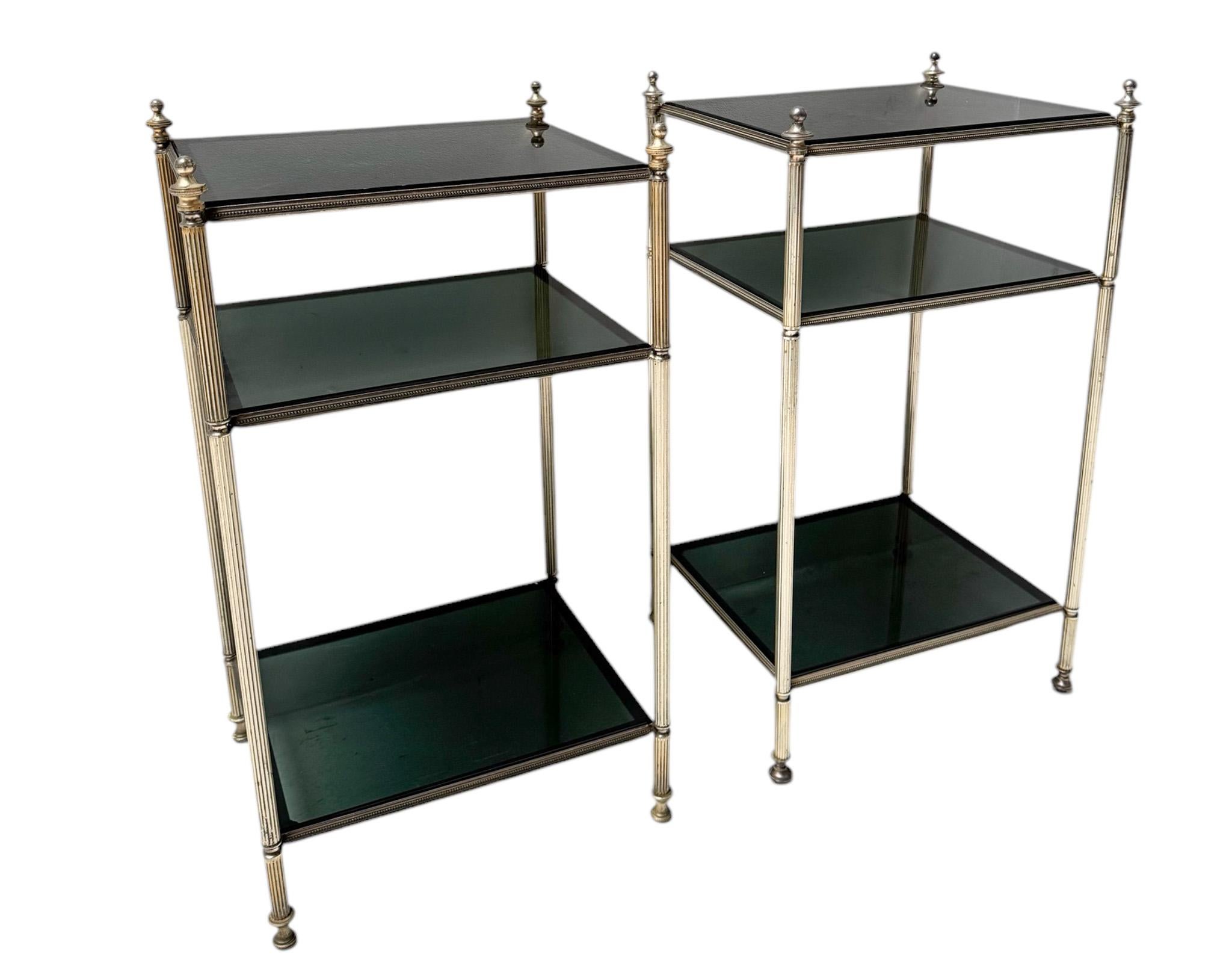 Impresionante y elegante par de mesas auxiliares Hollywood Regency.
Diseño de Maison Jansen.
Llamativo diseño francés de la década de 1940.
Bastidores originales de latón niquelado con tres pisos y patas estriadas.
Seis tapas originales de cristal