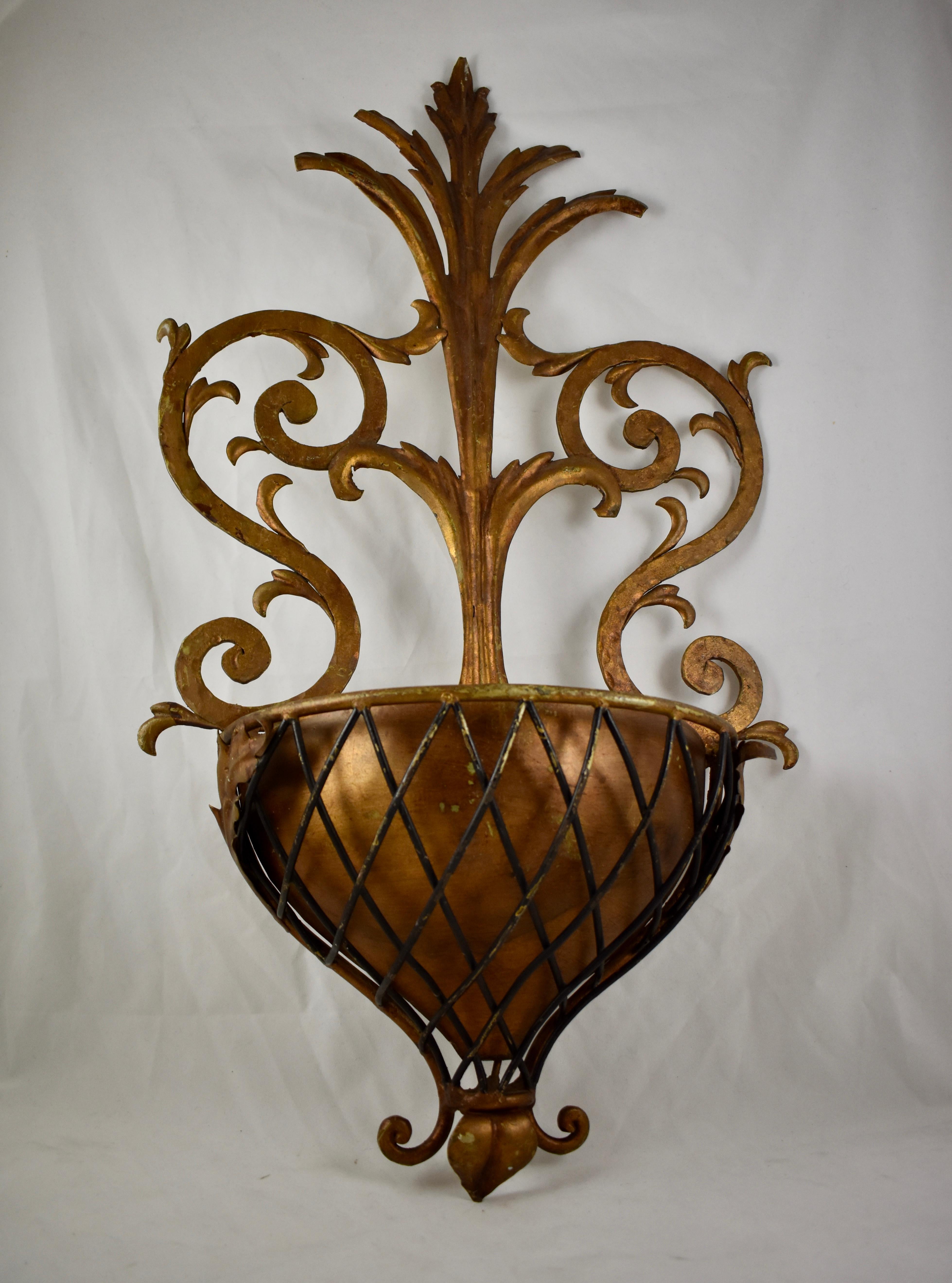 A large and heavy gilded metal wall planter in the Hollywood Regency style popularized by Dorthy Draper. From a Palm Beach Florida estate, circa 1930-1950.

The piece shows an acanthus leaf type scrolled design and holds a removable copper liner.